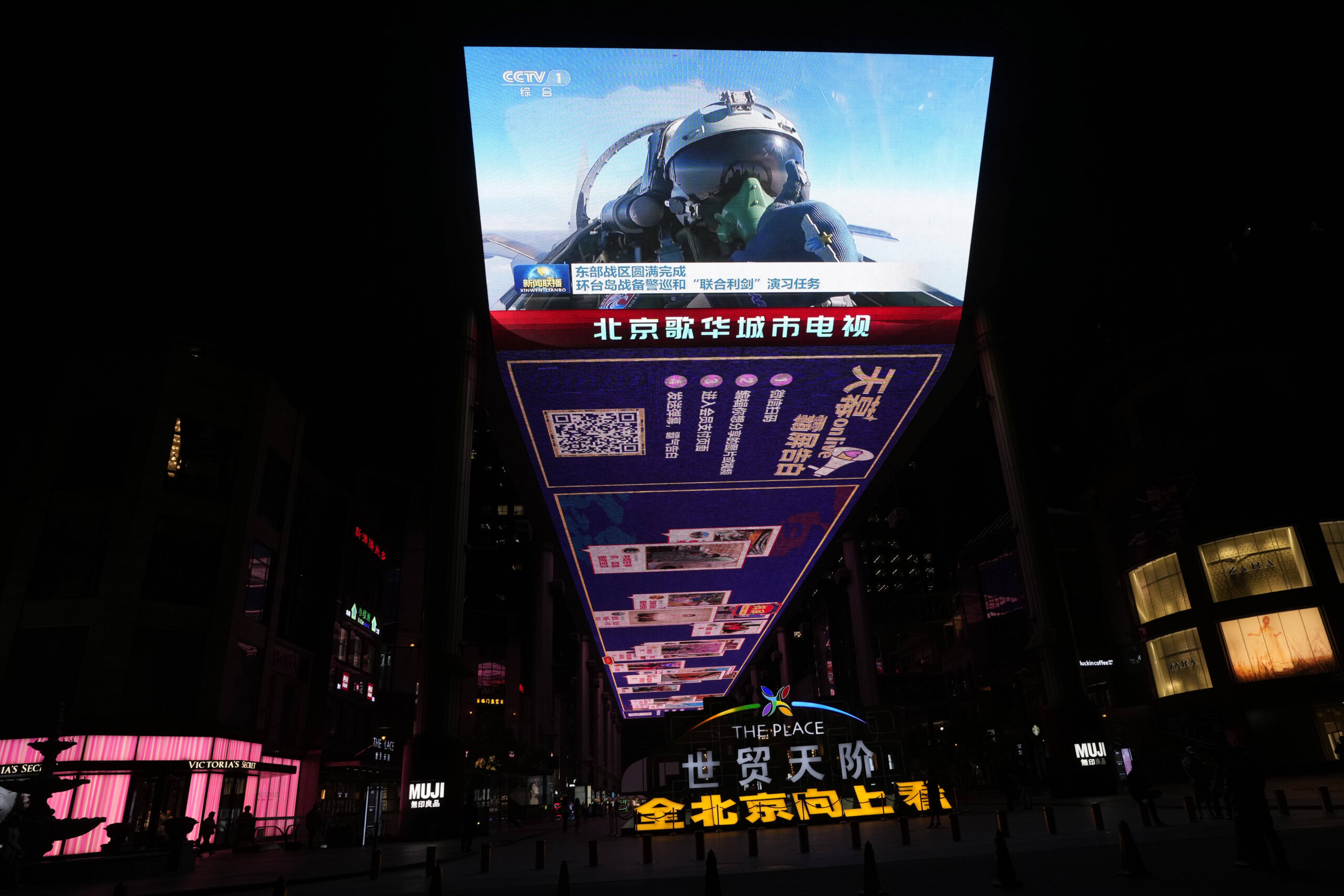 Una pantalla exterior muestra a un piloto de caza chino dando un pulgar hacia arriba durante el recién concluido ejercicio de Espada Conjunta alrededor de Taiwán, durante las noticias de la noche en Pekín, el lunes 10 de abril de 2023. El ejército chino dijo estar 