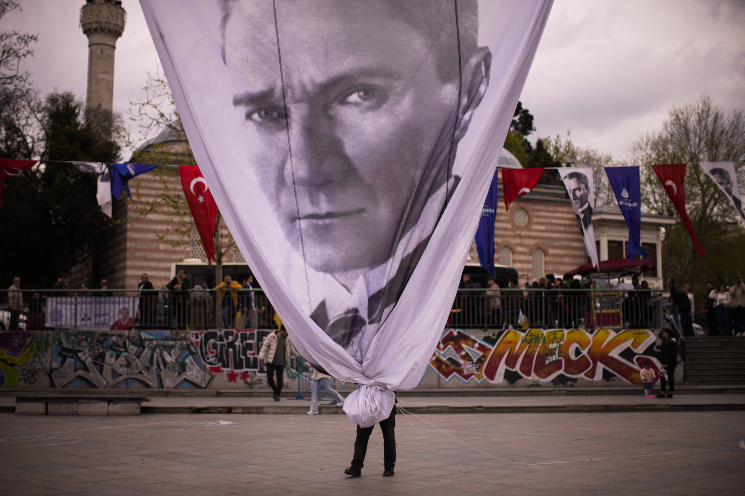 Un trabajador retira una pancarta gigante de Mustafa Kemal Ataturk, fundador de la Turquía moderna, al final de un mitin del alcalde de Estambul y miembro del principal partido de la oposición CHP, Ekrem Imamoglu, en Estambul, Turquía, el miércoles 26 de abril de 2023 © AP Foto/Francisco Seco