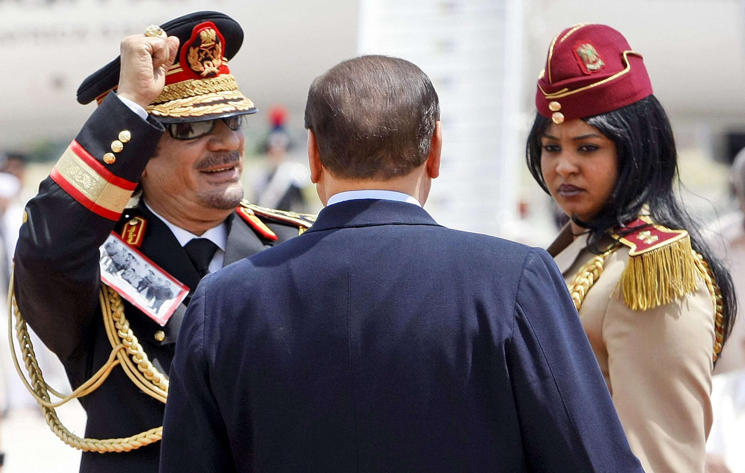 En esta foto tomada el 10 de junio de 2009, el líder libio Moammar Gadhafi, a la izquierda, y el primer ministro italiano Silvio Berlusconi, por detrás, pasan revista a una guardia de honor a la llegada de Gadhafi al aeropuerto militar Ciampino de Roma © ANDREW MEDICHINI/AP/SIPA