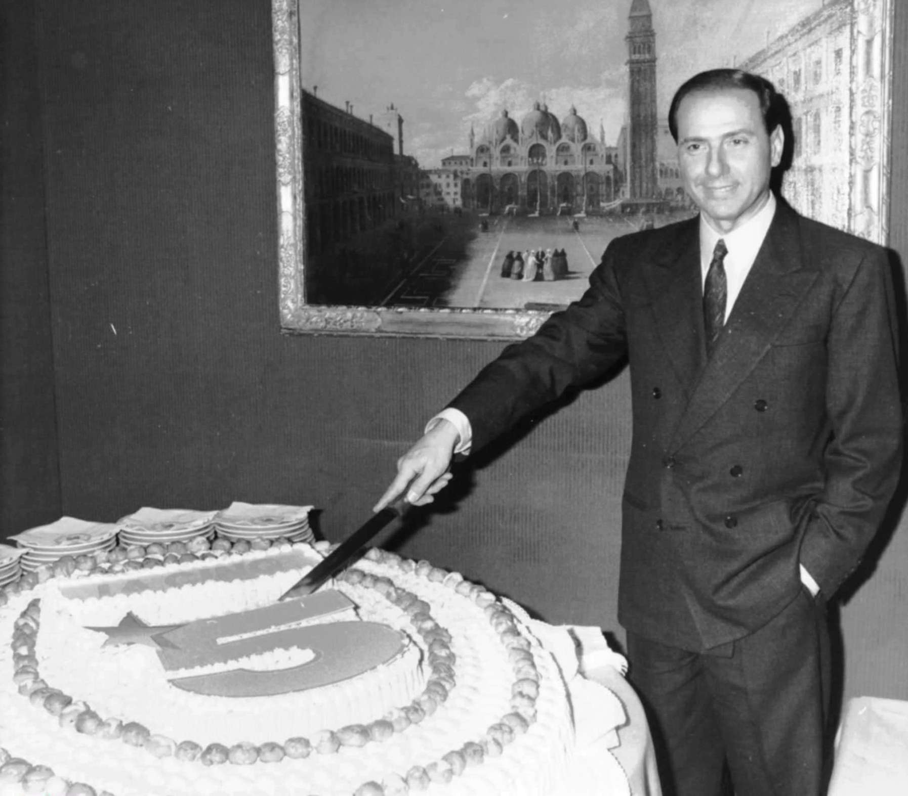 Silvio Berlusconi corta una tarta con la forma del logotipo de su cadena de televisión privada 