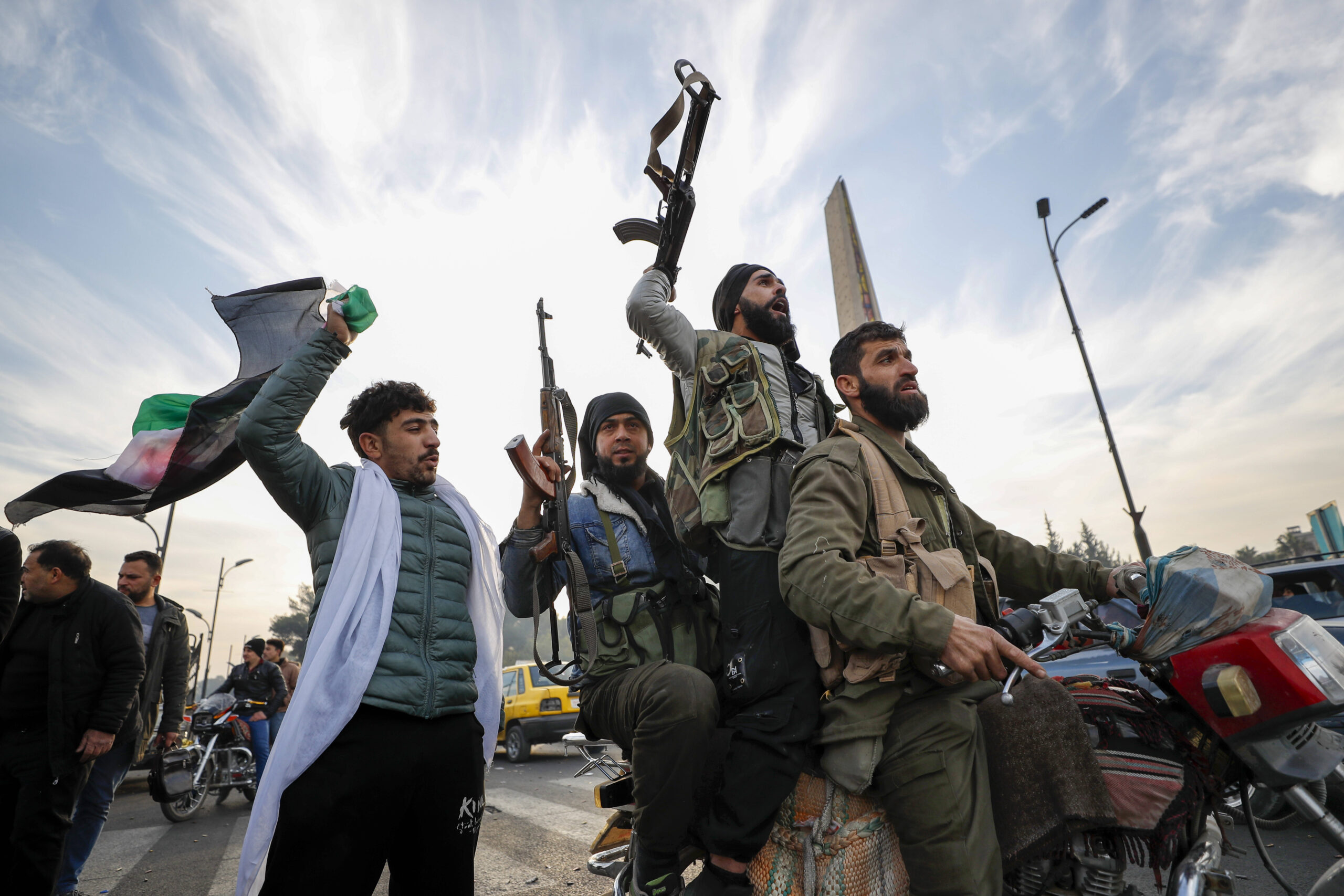 Combatientes de la oposición siria celebran el colapso del gobierno sirio en Damasco, Siria, el domingo 8 de diciembre de 2024. © AP Photo/Omar Sanadiki