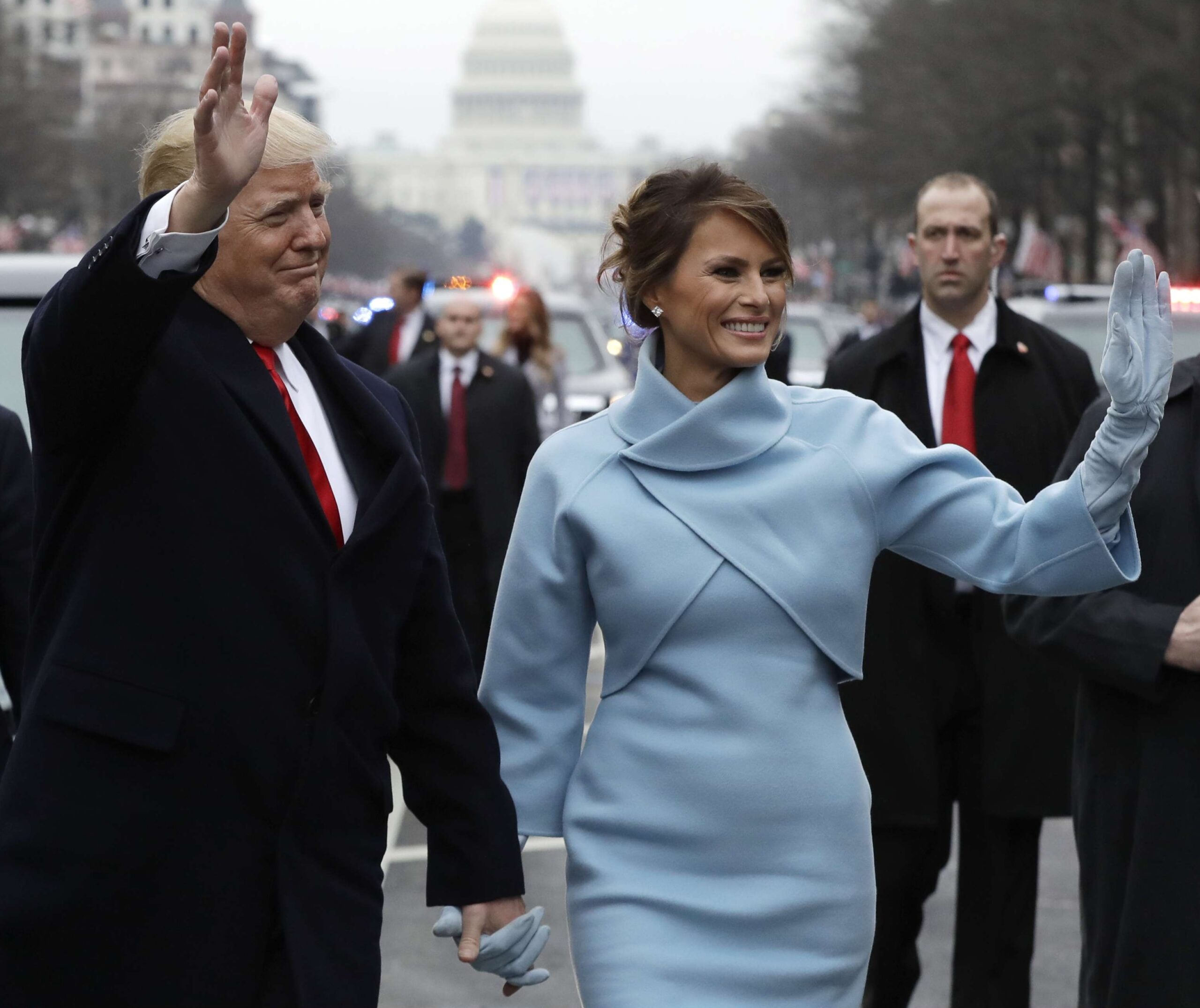 El presidente Donald Trump saluda mientras camina con la primera dama Melania Trump durante el desfile de inauguración en la avenida Pennsylvania en Washington, el viernes 20 de enero de 2016. © AP Foto/Evan Vucci