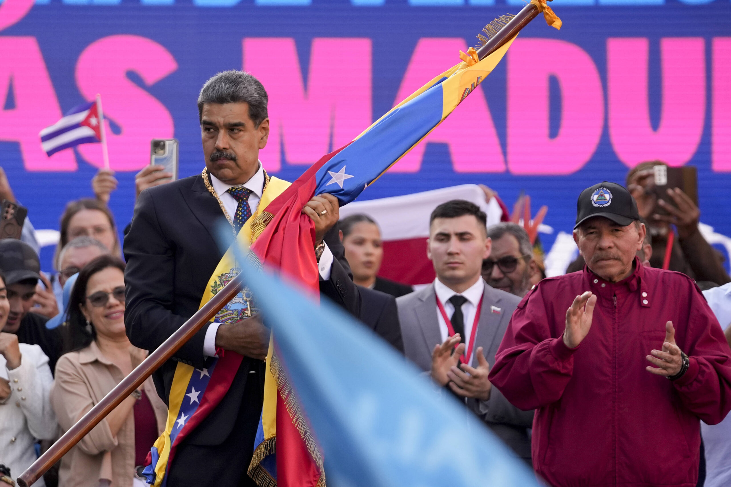 El presidente de Venezuela, Nicolás Maduro, sostiene una bandera nacional mientras el presidente de Nicaragua, Daniel Ortega, aplaude durante una ceremonia de investidura de Maduro, quien juró para un tercer mandato de seis años, en Caracas, Venezuela, el viernes 10 de enero de 2025. © AP Foto/Cristian Hernandez