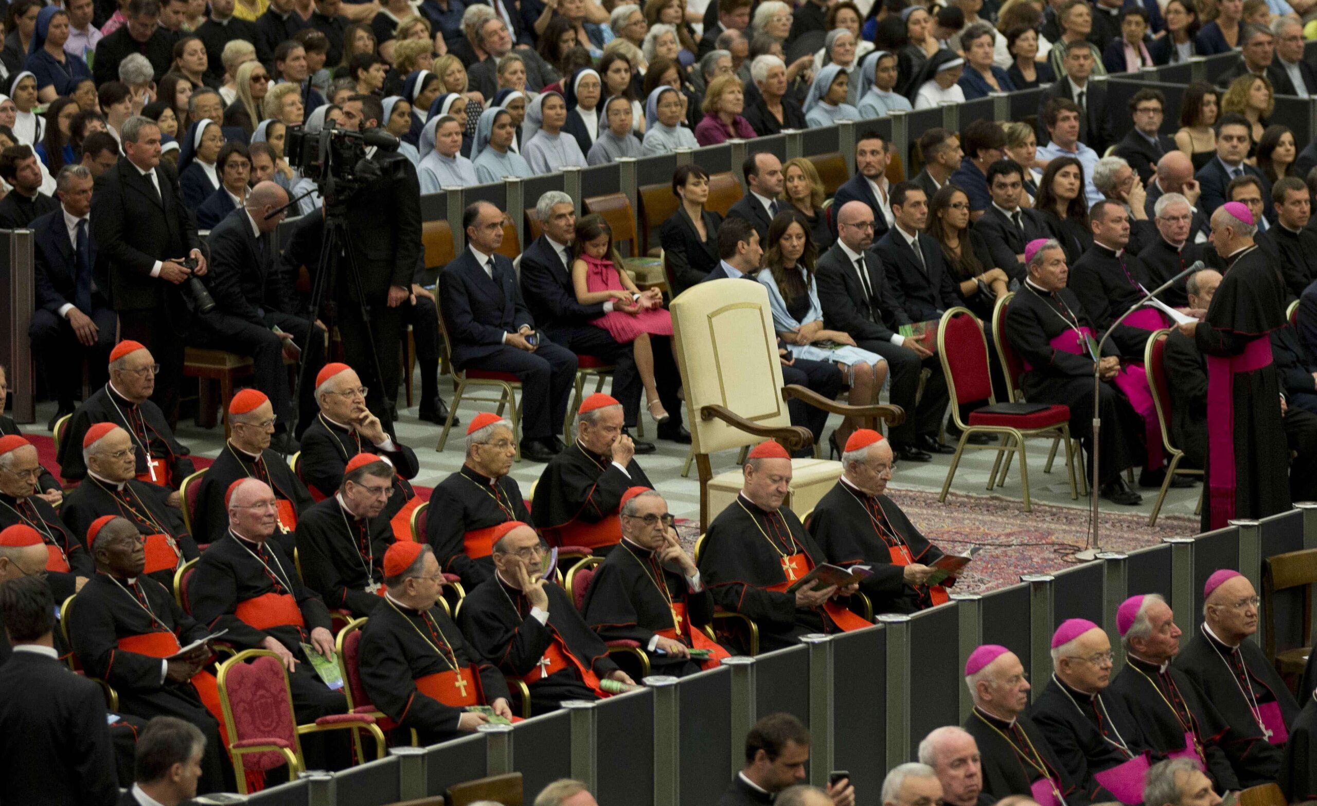 Cardenales, a la izquierda, sentados junto a la silla vacía del papa Francisco, escuchan a monseñor Rino Fisichella, no visible, leer un mensaje del pontífice antes del inicio del concierto dirigido por el director eslovaco Juraj Valcuha Mehta con la Orquesta de la RAI (televisión estatal italiana), en el Aula Pablo VI del Vaticano, el sábado 22 de junio de 2013. © AP Photo/Alessandra Tarantino