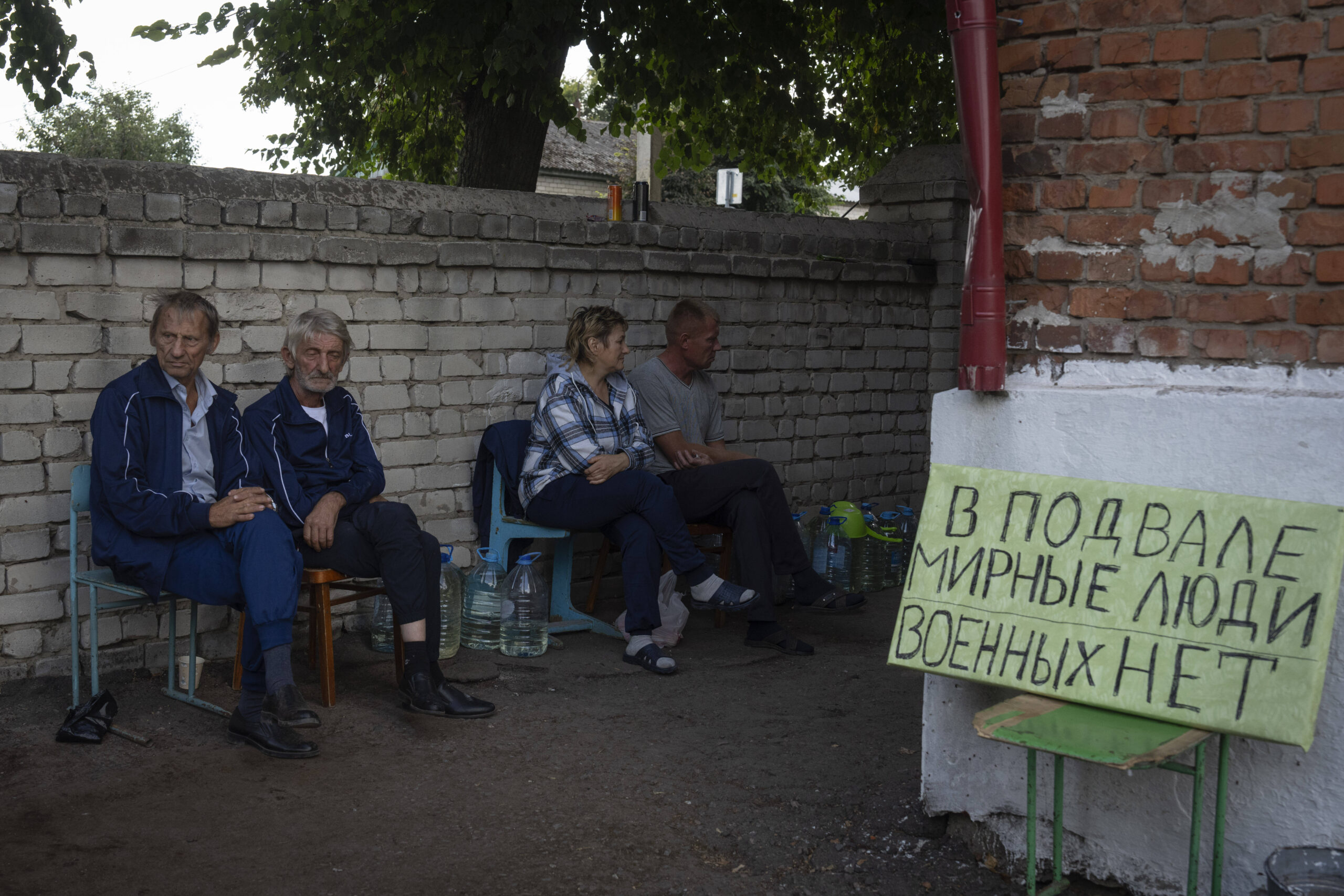 Vecinos sentados junto a un refugio en Soudja, en la región de Kursk, Rusia, el viernes 16 de agosto de 2024. El cartel indica «Civiles en un sótano. No militares». © /AP/SIPA