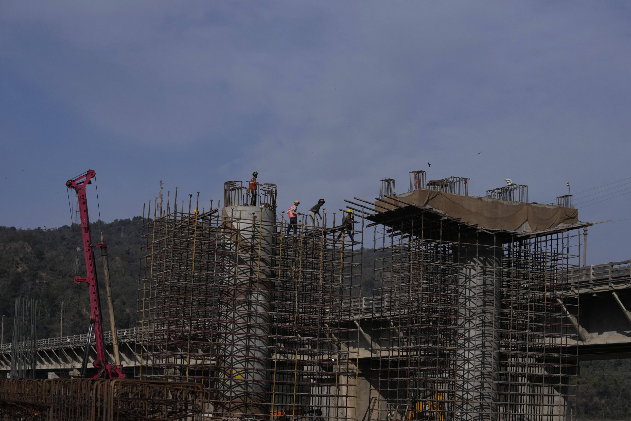 Obreros en una obra de construcción de la puente Tawi, en las afueras de Jammu, India, el martes 11 de febrero de 2025. © Foto AP/Channi Anand