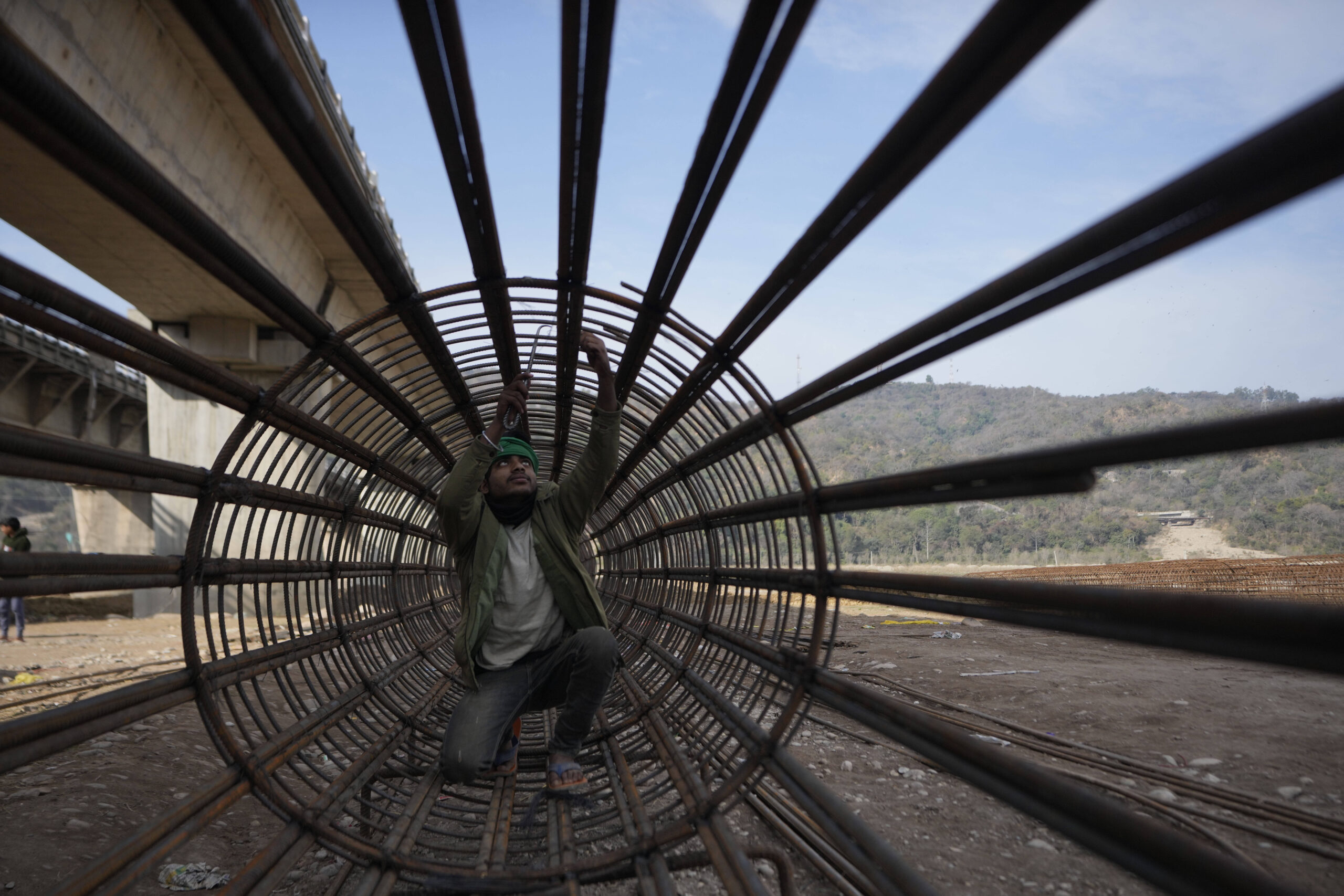 Obrero en una obra de construcción de la puente Tawi, en las afueras de Jammu, India, el martes 11 de febrero de 2025. © Foto AP/Channi Anand