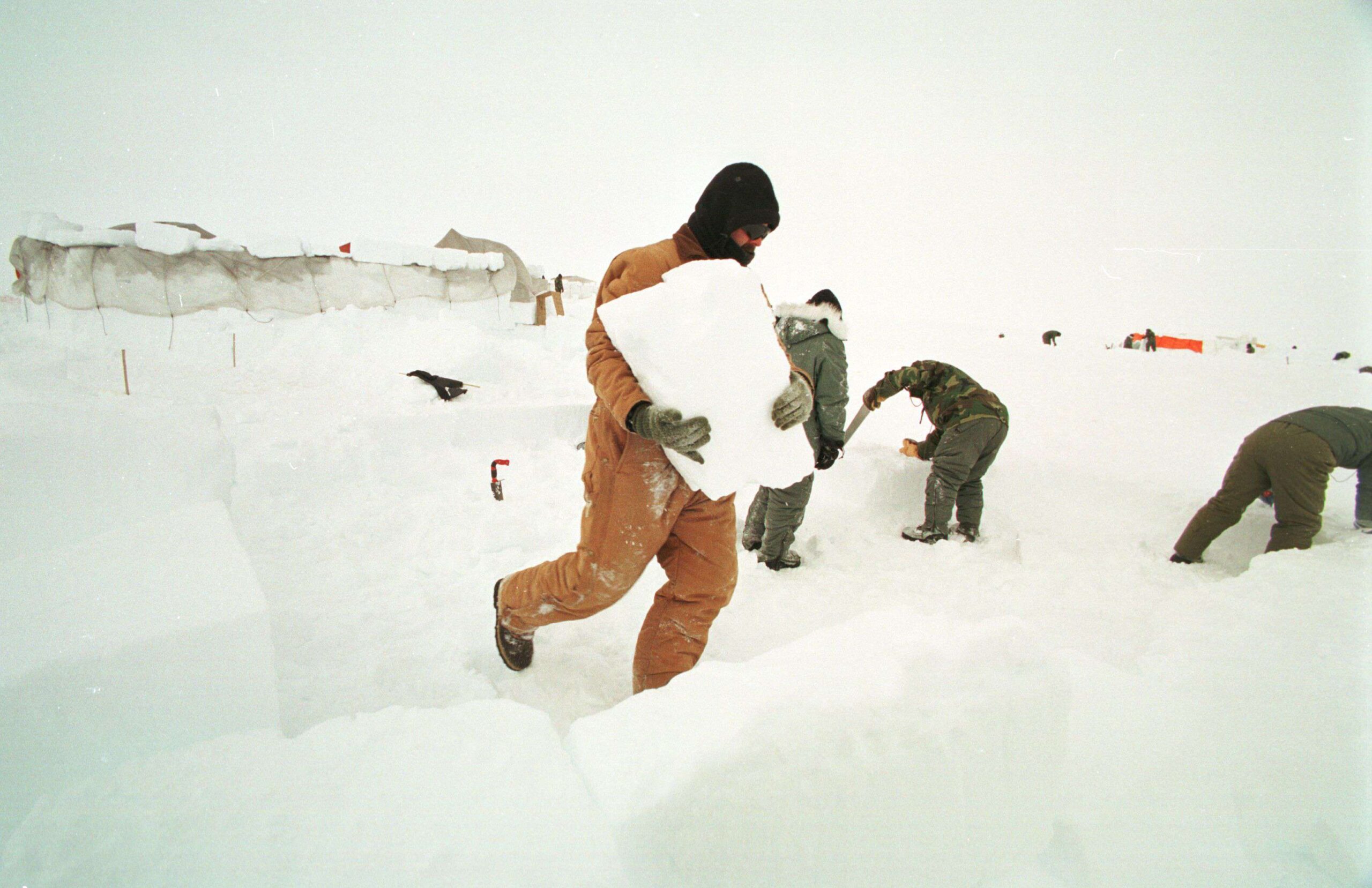 Miembros de la Fuerza Aérea de EE.UU. en Camp Raven, en el casquete glaciar de Groenlandia, cortan bloques de hielo con los que construirán un refugio. Se encuentran en el casquete glaciar de Groenlandia para entrenarse en supervivencia en el Ártico. Groenlandia, Kangerlussuaq, 19 de enero de 2025. © Rob Schoenbaum/ZUMA Press Wire/Shutterstock