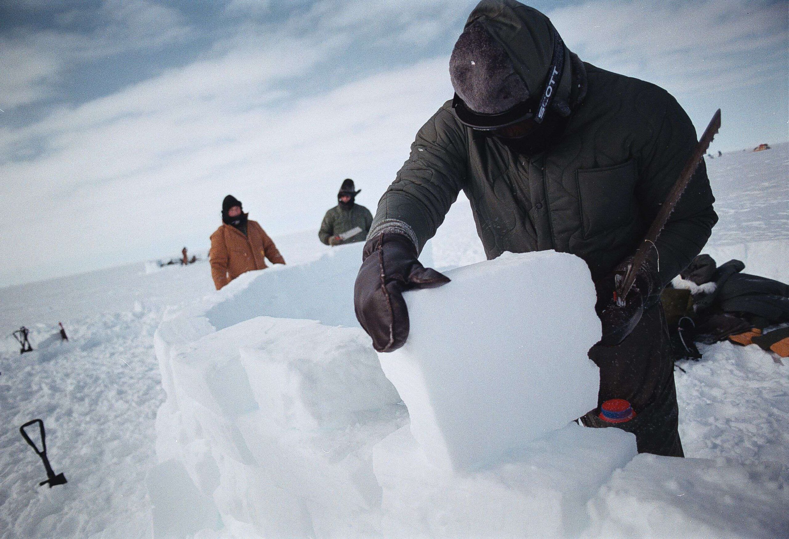 Tripulantes de las Fuerzas Aéreas de EE.UU. en Camp Rvaen, en el casquete glaciar de Groenlandia, cortan bloques de hielo con los que construirán un refugio. Se encuentran en el casquete glaciar de Groenlandia para entrenarse en supervivencia en el Ártico. Groenlandia, Kangerlussuaq, 19 de enero de 2025. © Rob Schoenbaum/ZUMA Press Wire/Shutterstock