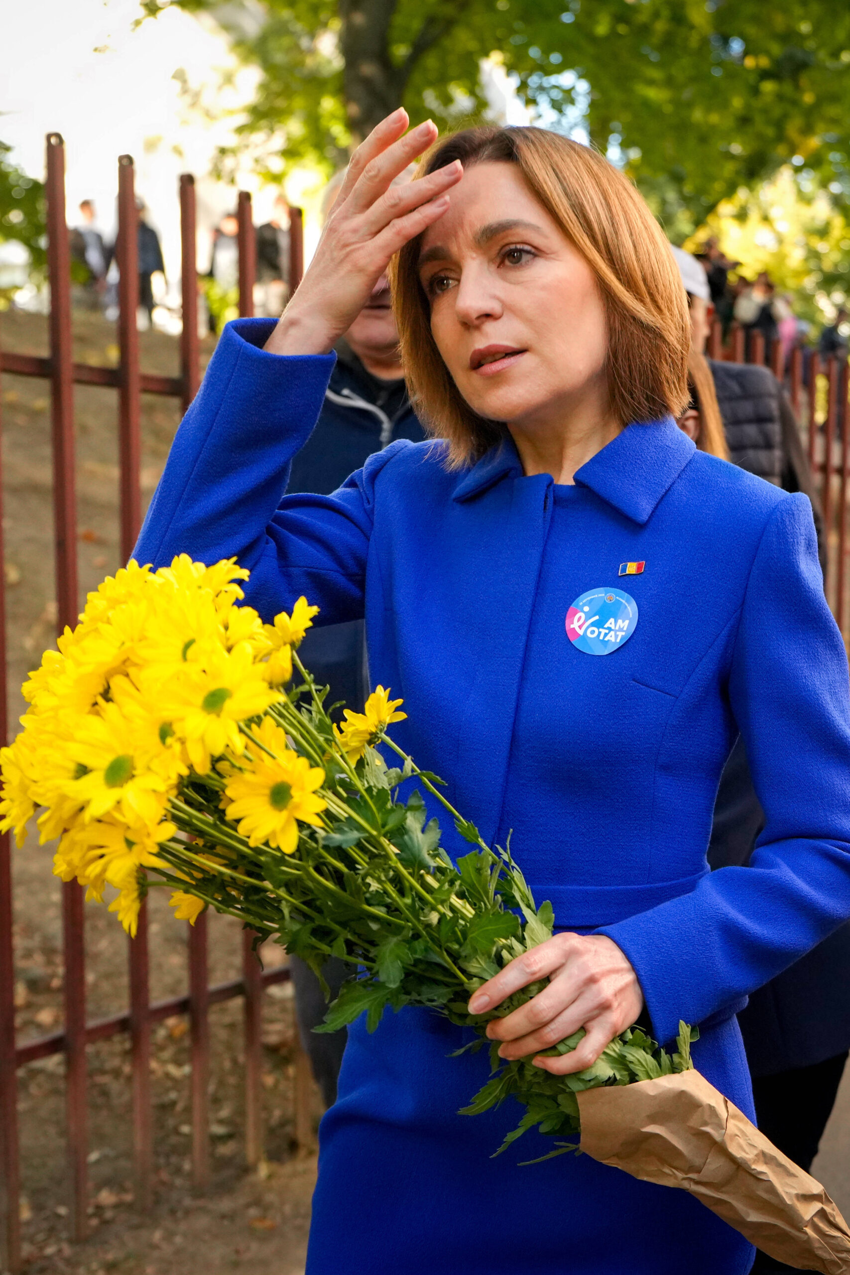 La presidenta moldava Maia Sandu sostiene un ramo de flores al salir de un colegio electoral.