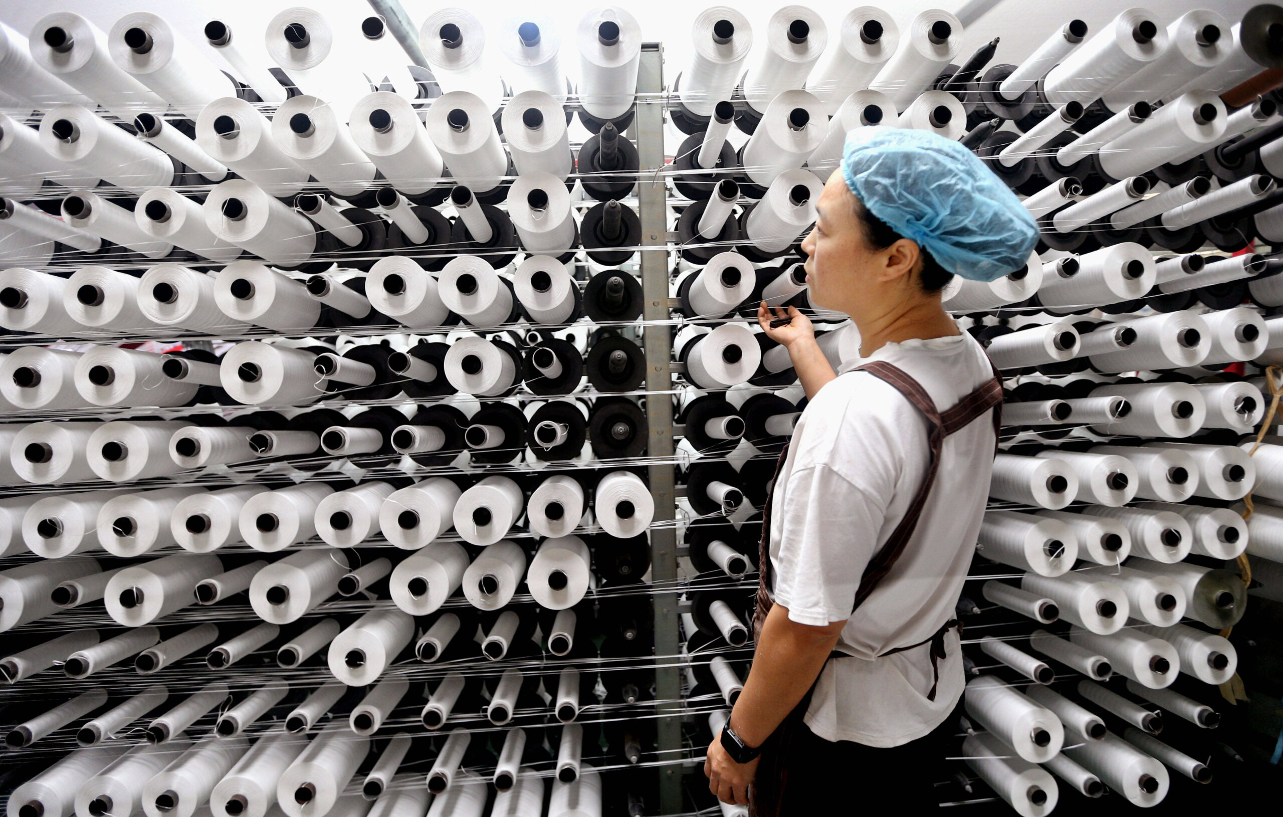 Una trabajadora trabaja en una cadena de producción de una empresa de fabricación de bolsas tejidas en el distrito de Lianyungang, en China, el 9 de octubre de 2025. © CFOTO/Sipa USA