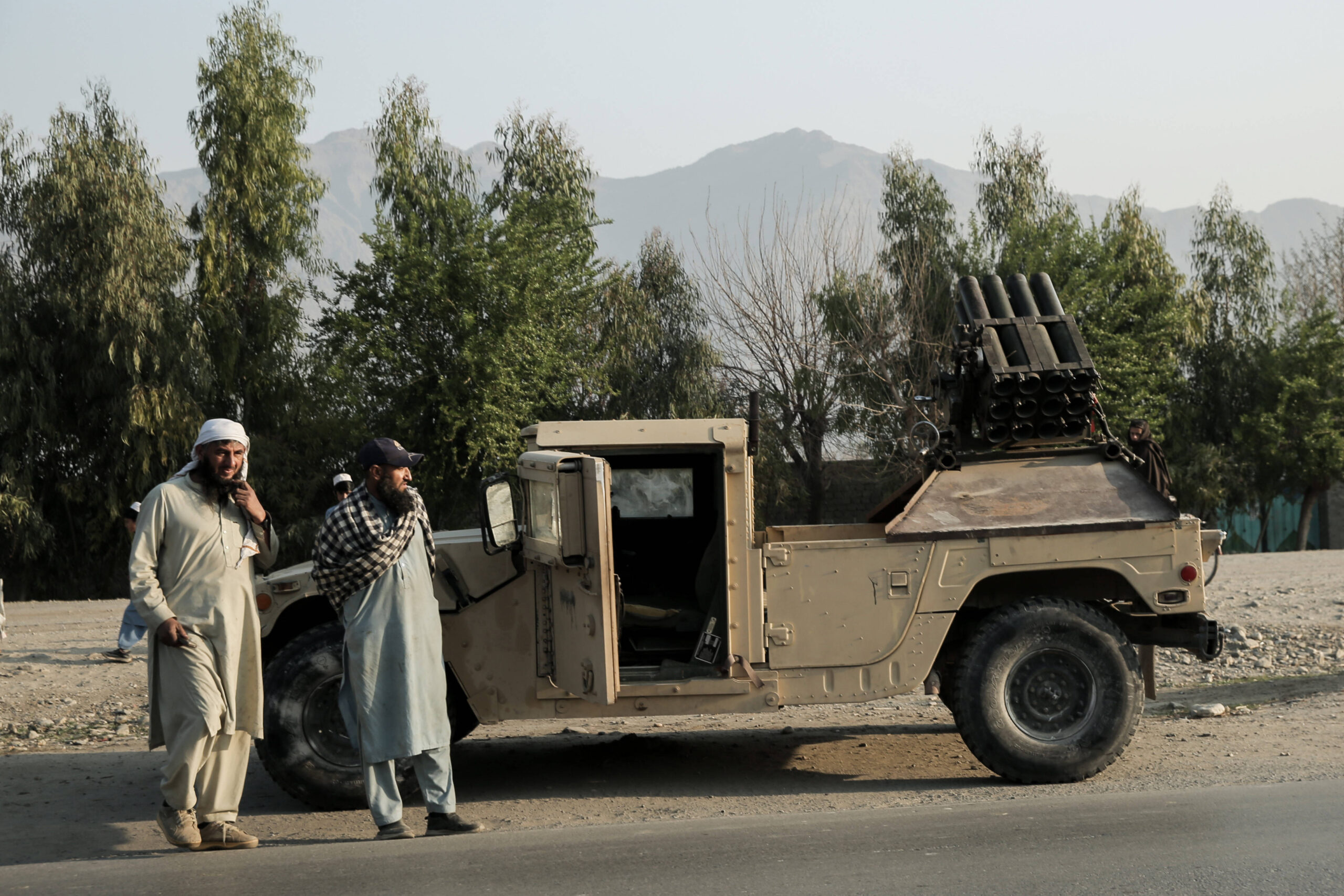 Combatientes talibanes montan guardia junto a un vehículo blindado en Torjam. © Sami Jan