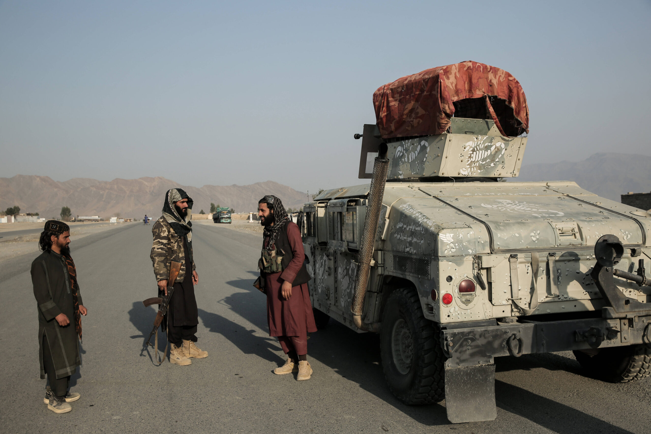 Combatientes talibanes montan guardia junto a un vehículo blindado en un puesto de control situado cerca del paso fronterizo de Torjam, entre Pakistán y Afganistán. © Sami Jan