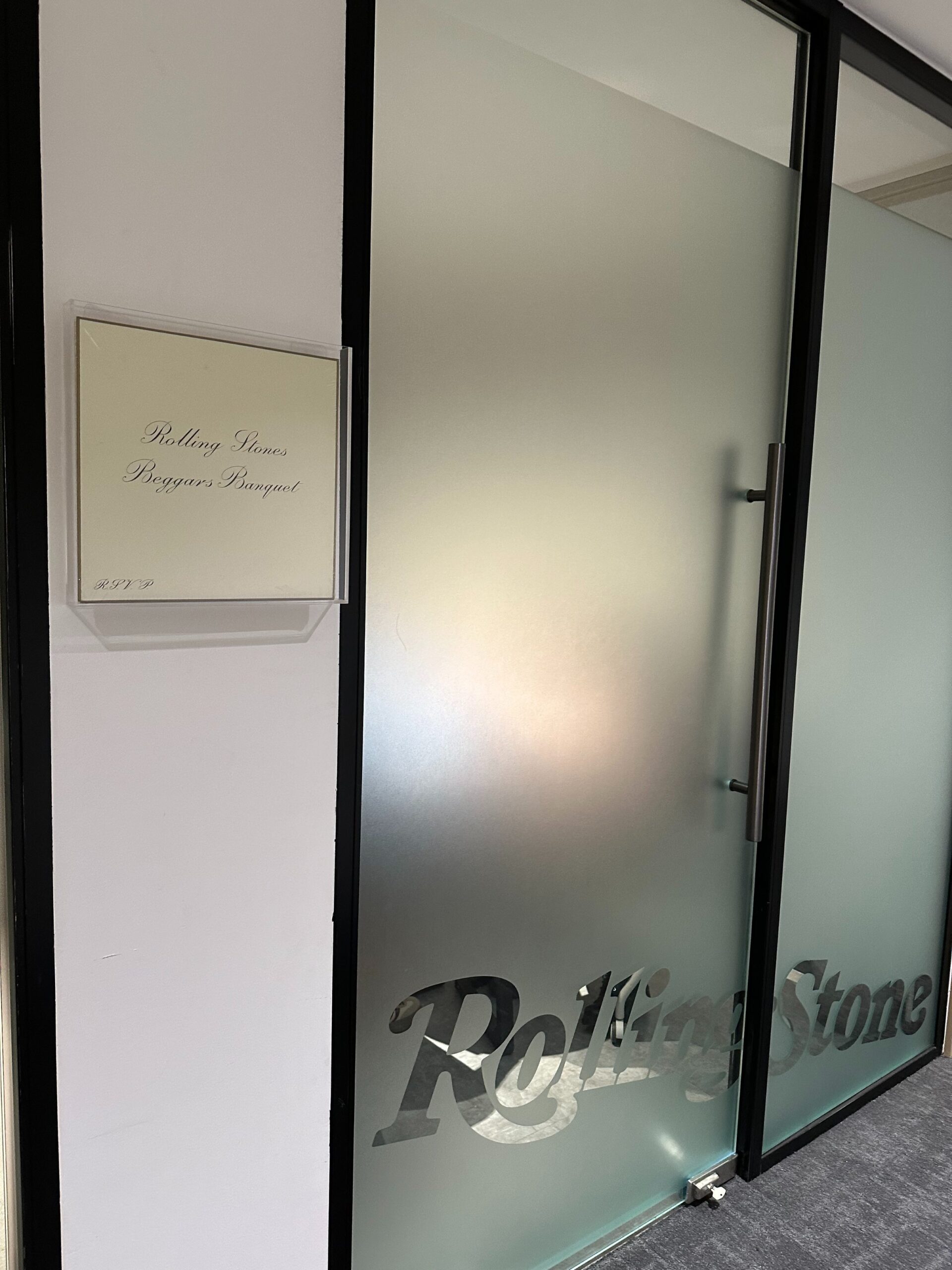 Sala Rolling Stones: en la vitrina, la portada color crema de Beggars Banquet (1968); en la puerta de cristal esmerilado, el logotipo del grupo. Foto: Crystal (@crystalsssup) / X.