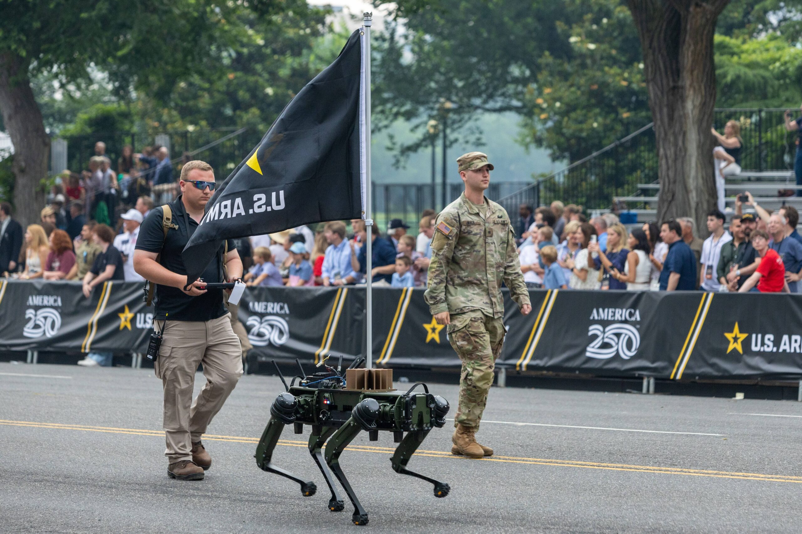 Un perro robot abanderado del Ejército de Estados Unidos, controlado a distancia por un operador vestido con una camiseta polo: a medio camino entre el folclore del Oeste y un simple artilugio, el desfile no acababa de decidirse sobre qué imagen del ejército quería mostrar. Foto: Hu Yousong / Xinhua