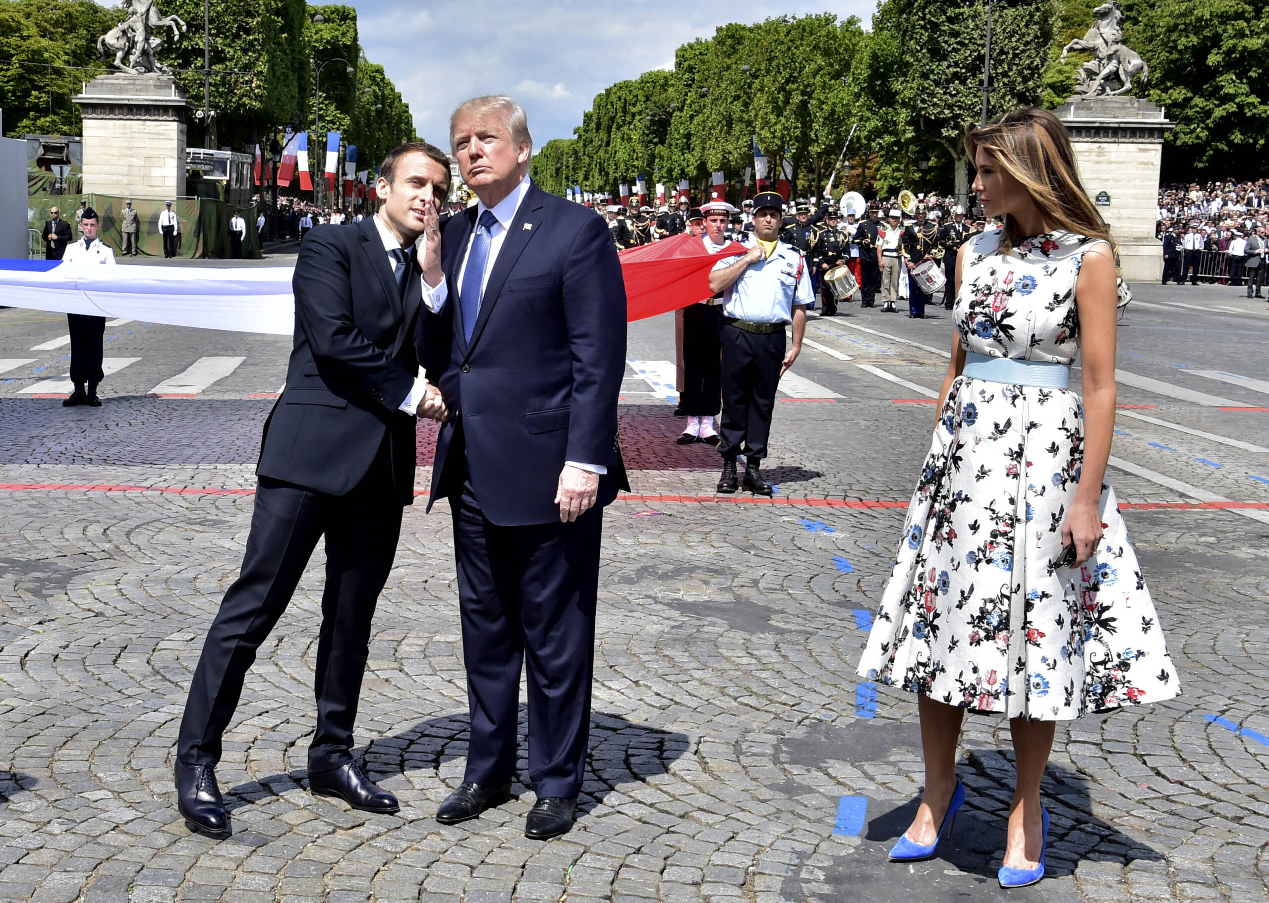 Emmanuel Macron saluda a Donald Trump al término del desfile del 14 de julio de 2017 en los Campos Elíseos, bajo la mirada de Melania Trump. Foto: Carolyn Kaster/AP
