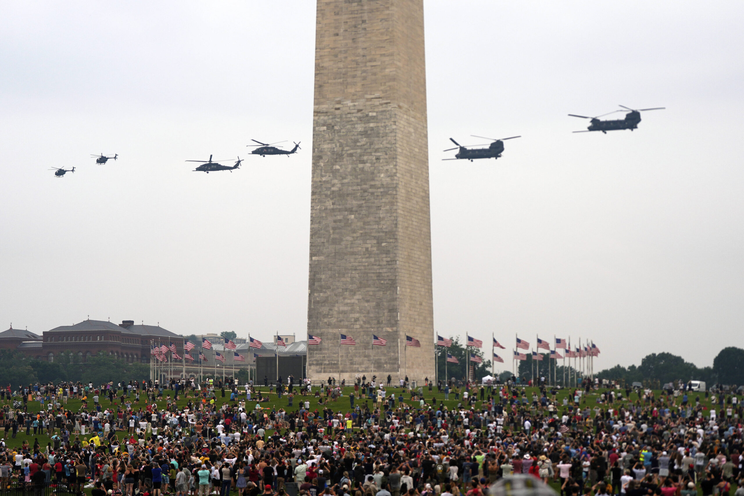 Helicópteros Black Hawk y Chinook volando en formación sobre el National Mall, ante una multitud dispersa. Foto: Julia Demaree Nikhinson/AP
