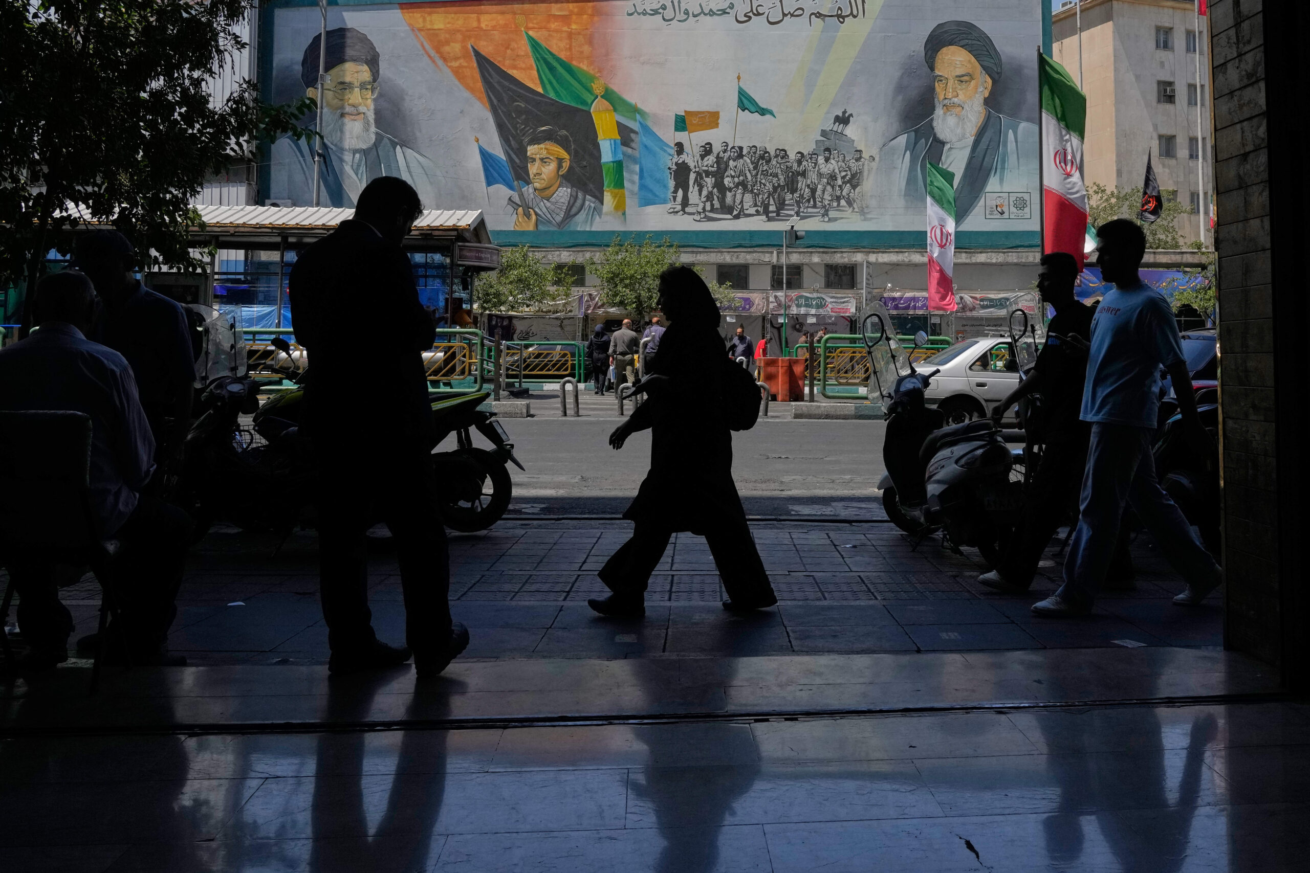 Mural en el que aparecen retratos del ayatolá Jomeini (a la derecha), del ayatolá Ali Jamenei y de las fuerzas paramilitares Basij. © AP Photo/Vahid Salemi