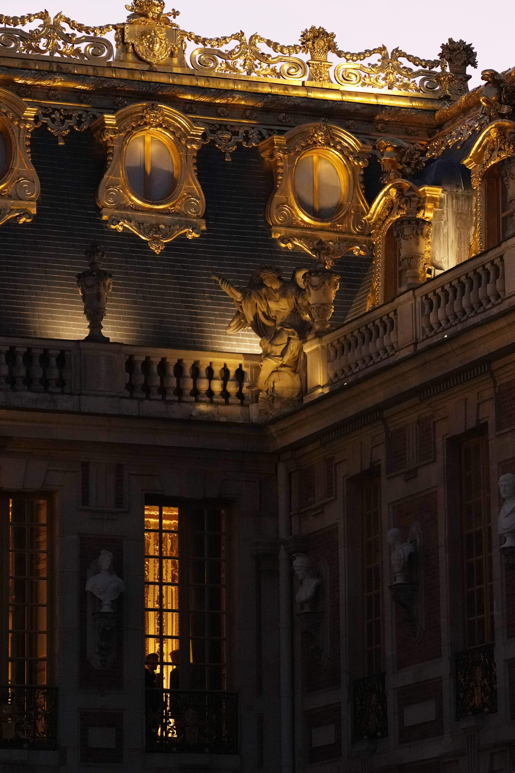 Los tejados del Patio de Mármol del Palacio de Versalles al atardecer, con sus adornos en hoja de oro, sus buhardillas esculpidas y sus estatuas del ático, iluminados con motivo de la cena ofrecida al margen de la cumbre del G7 de Évian.