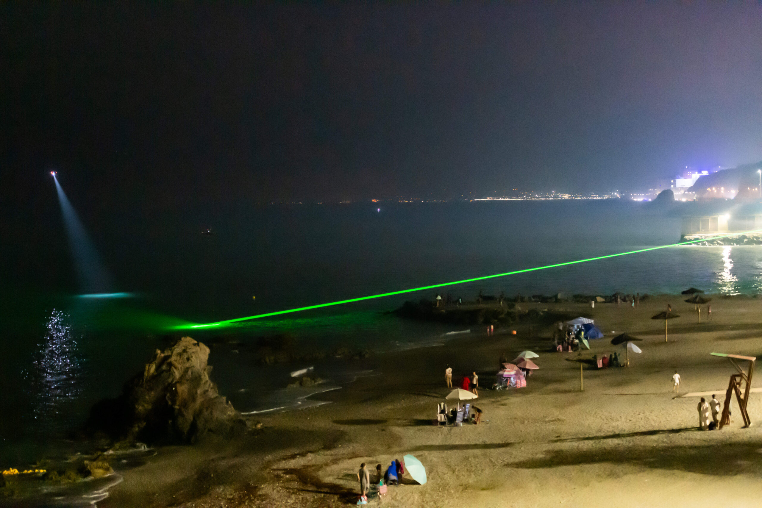 En la noche del 29 de julio, el láser de la Guardia Civil barre la bahía para localizar a los nadadores que intentan llegar a Ceuta, bajo el foco de un helicóptero. © AP Photo/Antonio Sempere/SIPA