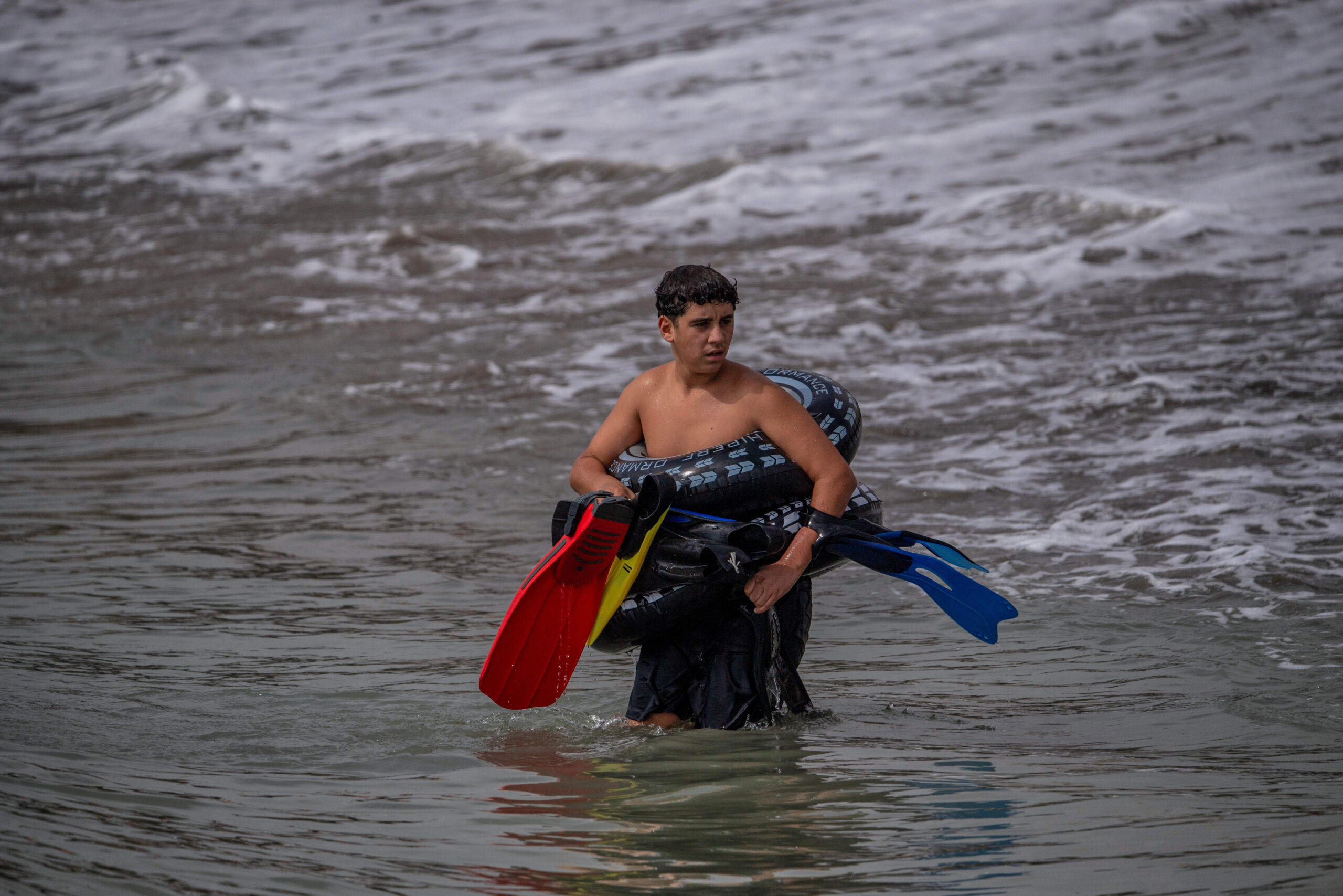 Aletas y flotador con forma de neumático: ahora se cruza la frontera con el equipamiento de playa, jueves 30 de julio de 2026. © AP Photo/Antonio Sempere/SIPA