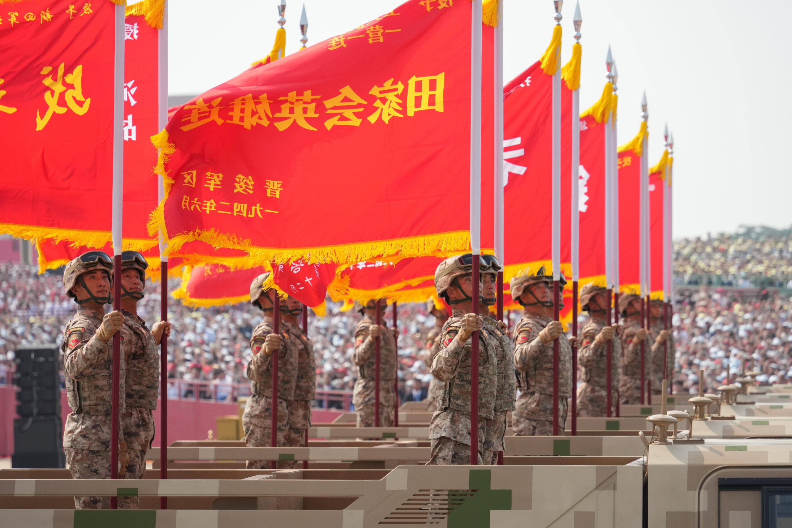 Las banderas de honor de las unidades históricas, izadas sobre vehículos blindados: cada bandera lleva el nombre de una batalla de la guerra contra Japón. Foto oficial