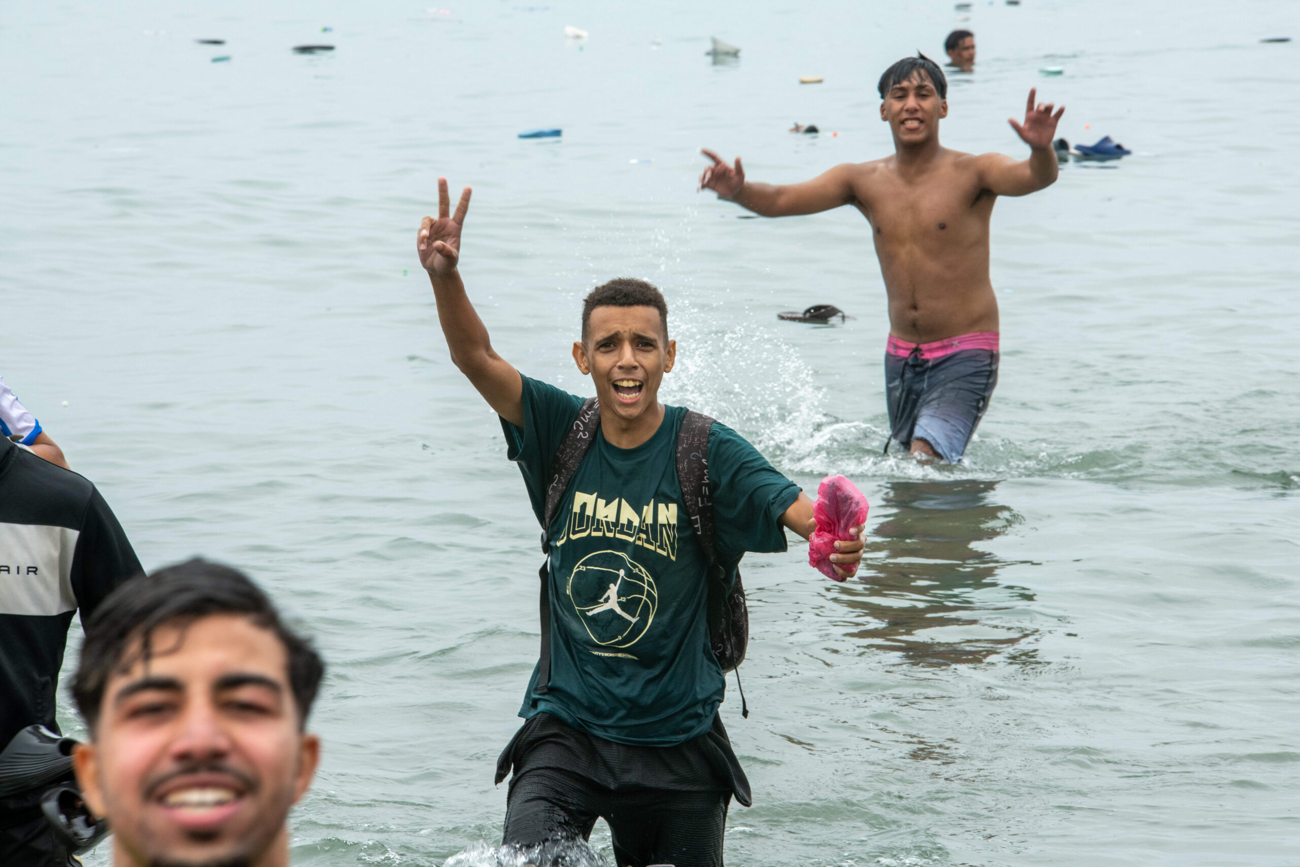Con los dedos en forma de V y gritos de alegría: unos jóvenes salen del agua en Ceuta, el 31 de julio de 2026. Foto: Juan Carlos Lucas