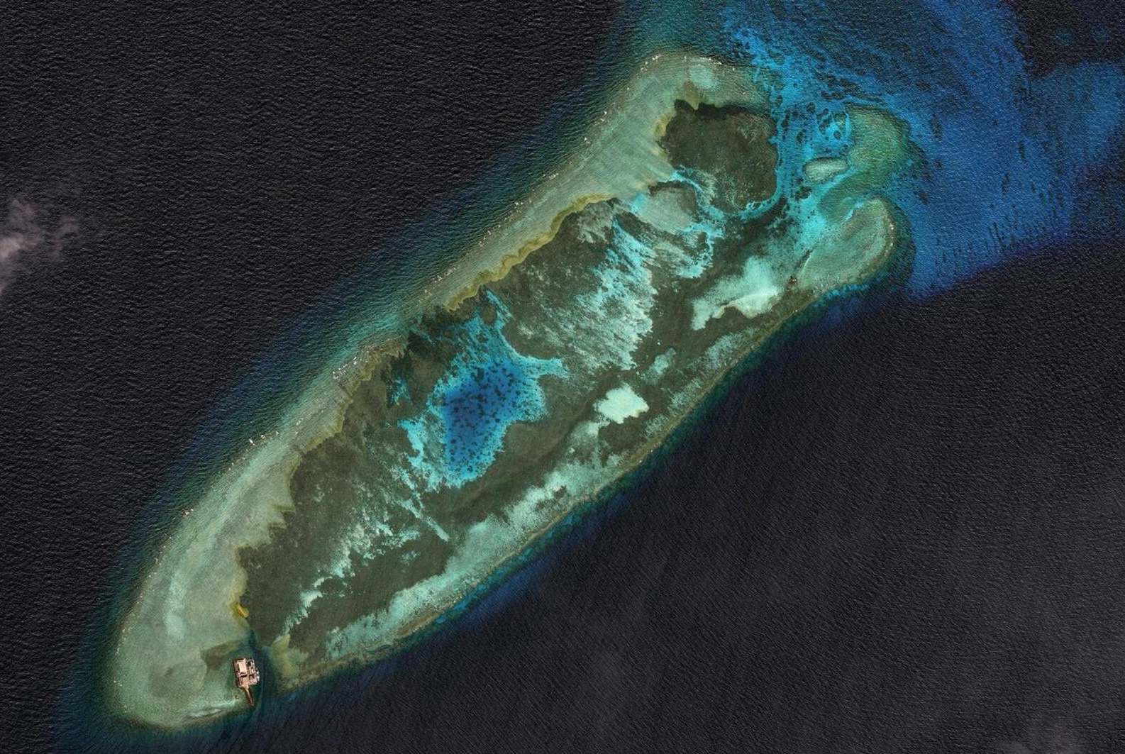 El arrecife de Fiery Cross (Yongshu), en el archipiélago de las Spratly, antes de que Pekín iniciara las grandes obras de relleno en 2014. Apenas visible con marea alta y ocupado desde 1988 por un simple puesto de observación, este banco de coral aún formaba parte de ese mar que los mapas representan como un «vasto espacio blanco y vacío», un espacio de libre circulación que, sin embargo, China reclama casi en su totalidad en virtud de la «línea de nueve trazos».