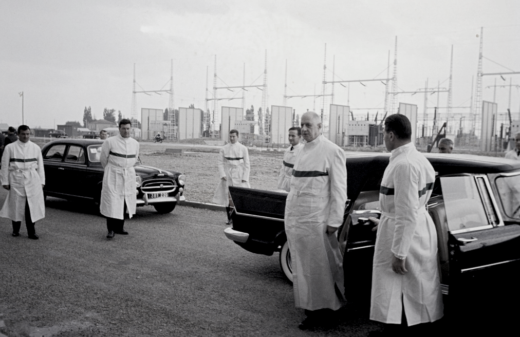 Pierrelatte, 24 de septiembre de 1963. Vestido con el mono blanco reglamentario y equipado con ropa de protección, el general de Gaulle baja del coche a su llegada a la planta de separación isotópica de la CEA, pieza clave de la fuerza de ataque francesa, rodeado de sus guardaespaldas.