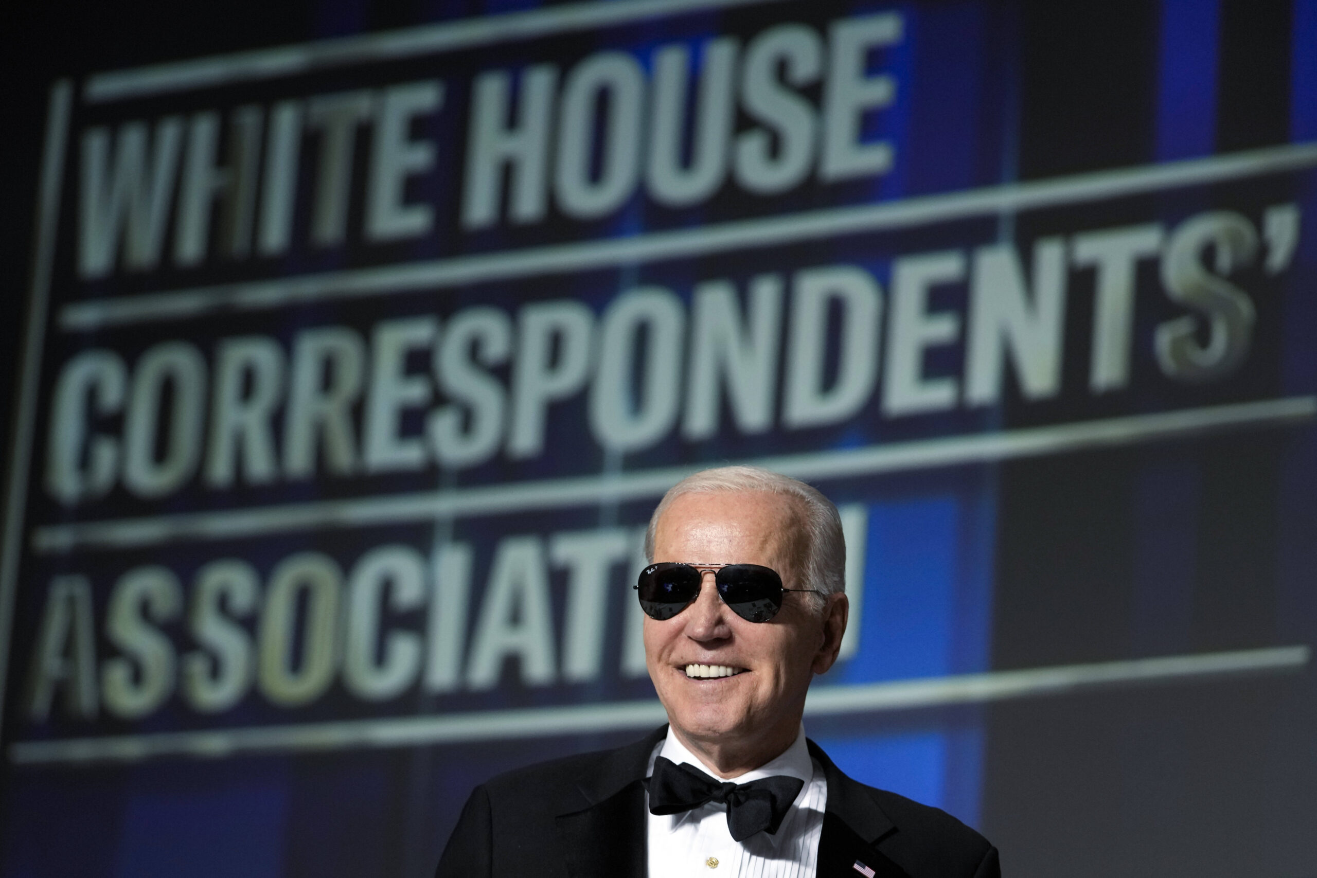 Le président Joe Biden enfile des lunettes de soleil après avoir fait une blague sur le fait de devenir le personnage de 
