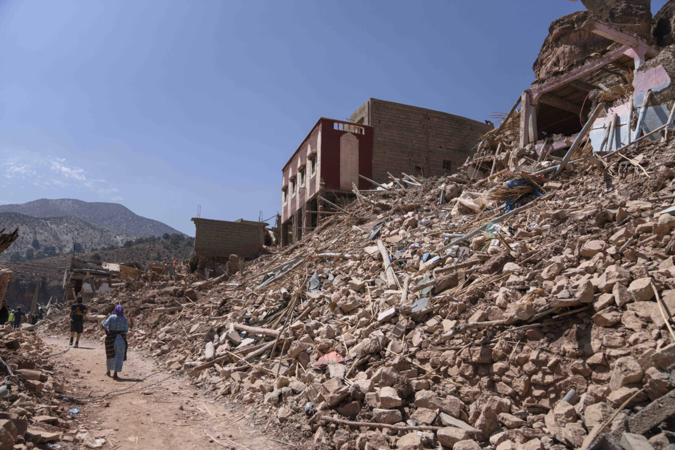 Des personnes marchent au milieu des décombres causés par le tremblement de terre, dans la ville d’Imi N’tala, près de Marrakech, au Maroc, mardi 12 septembre 2023. © AP Photo/Mosa’ab Elshamy