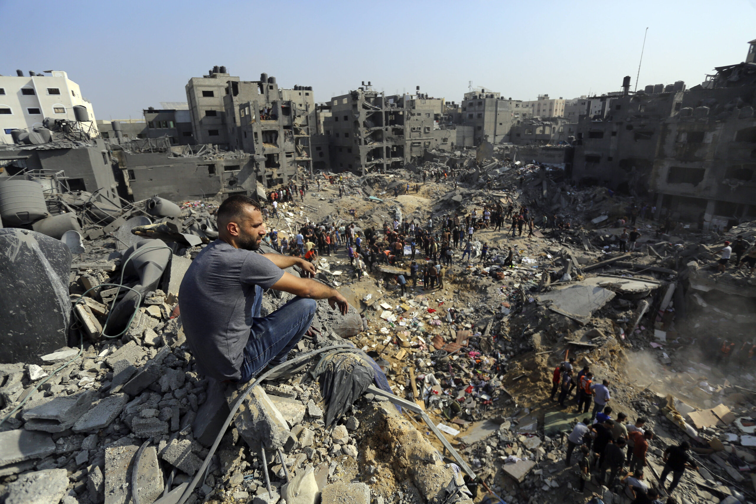Un homme est assis sur les décombres tandis que d'autres se promènent parmi les débris des bâtiments qui ont été ciblés par les frappes aériennes israéliennes dans le camp de réfugiés de Jabaliya, dans le nord de la bande de Gaza, mercredi 1er novembre. AP Photo/Abed Khaled