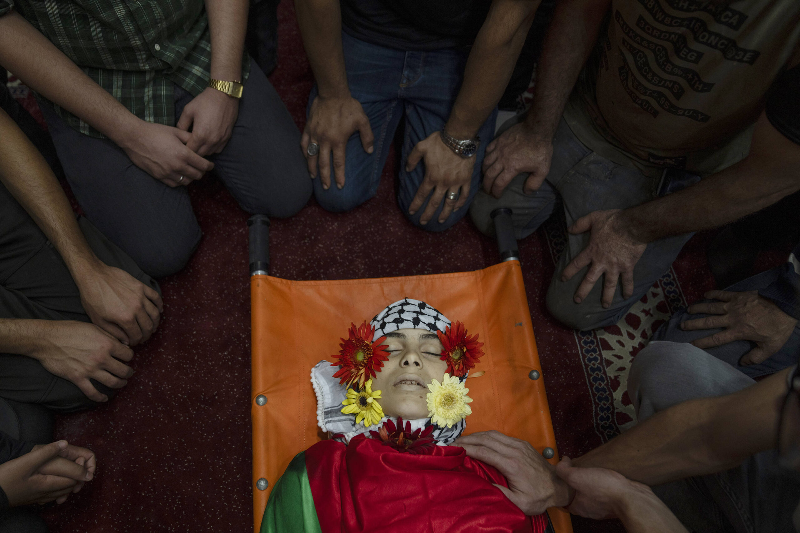 Des Palestiniens jettent un dernier regard sur le corps d'Ayham Al-Shafi, 14 ans, lors de ses funérailles dans la ville de Ramallah en Cisjordanie, jeudi 2 novembre 2023. Shafi et un autre Palestinien ont été tués lors d'un raid de l'armée israélienne à Ramallah tôt le matin, a déclaré le ministère palestinien de la Santé.© AP Photo/Nasser Nasser