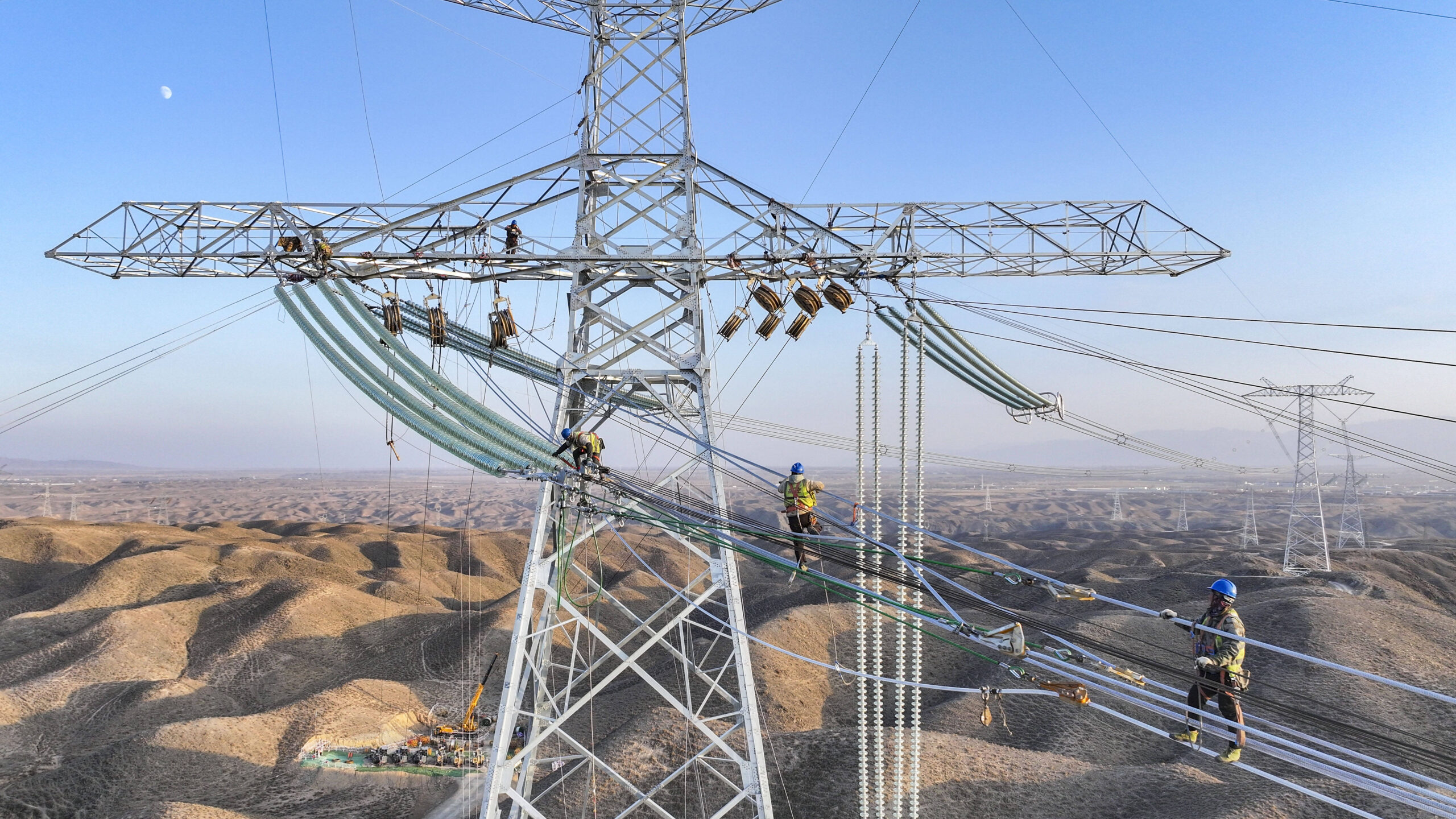 Des ouvriers mettent en place un réseau électrique pour le projet de ligne de transmission UHVDC Hami-Chongqing de 800 kilovolts à haute altitude dans la ville de Zhangye, dans la province du Gansu au nord-ouest de la Chine, le 14 novembre 2024. © Photo de CFOTO/Sipa USA