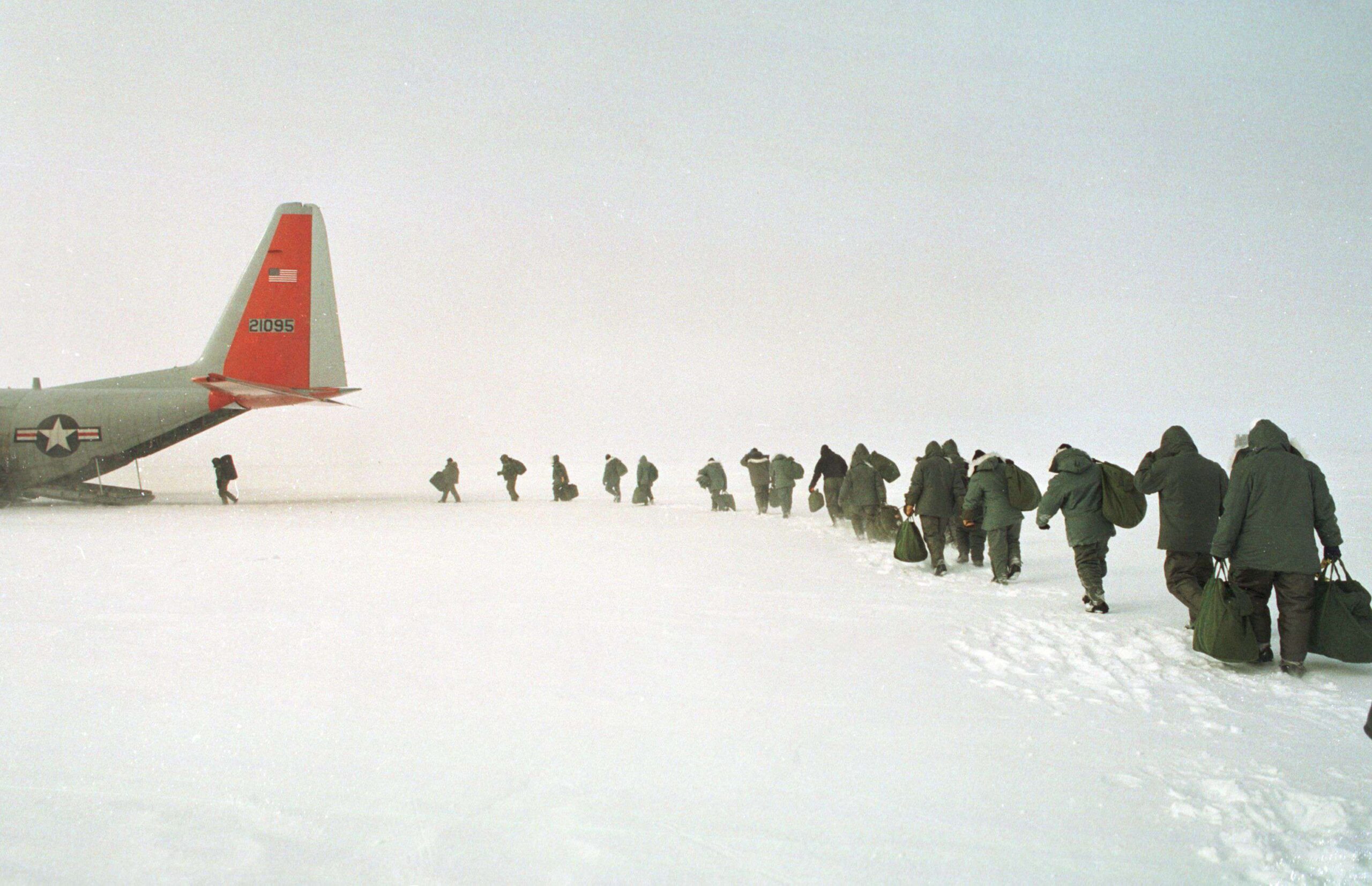 Des membres d'équipage de l'USAF montent à bord d'un avion de transport C-130 équipé de skis de la Garde nationale aérienne de New York après avoir suivi une formation de survie en Arctique sur la calotte glaciaire du Groenland. L'avion est exploité par la 109e escadre de transport aérien, spécialisée dans les missions polaires. Une structure recouverte de neige sur la calotte glaciaire du Groenland. Groenland, Kangerlussuaq, 19 janvier 2025. © Rob Schoenbaum/ZUMA Press Wire/Shutterstock