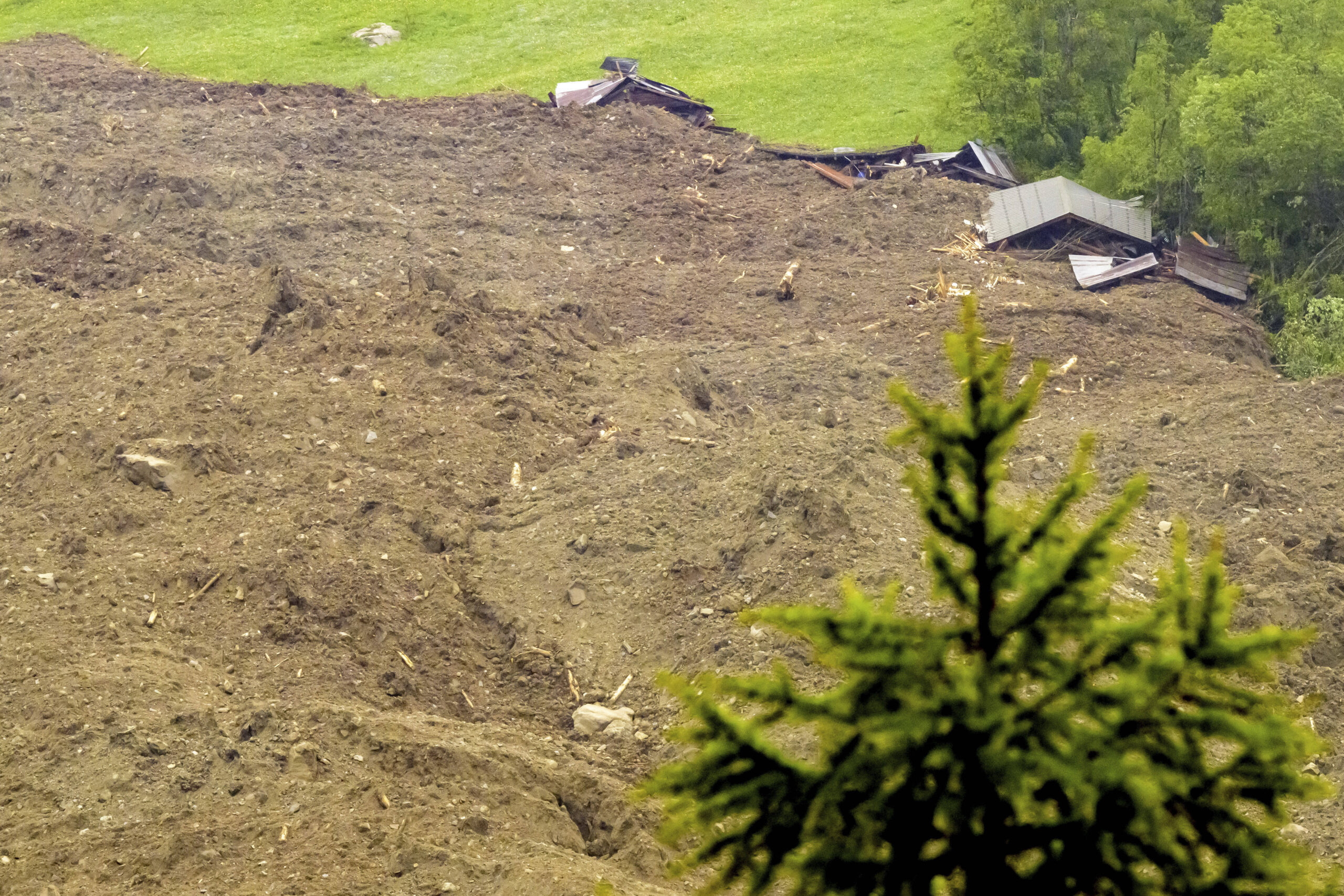 Une importante avalanche composée d'un mélange de glace, de roches, de neige et d'eau atteint le fond de la vallée à Wiler après l'effondrement du glacier de Birch au-dessus de Blatten, en Suisse, le mercredi 28 mai 2025. © Jean-Christophe Bott/Keystone via AP