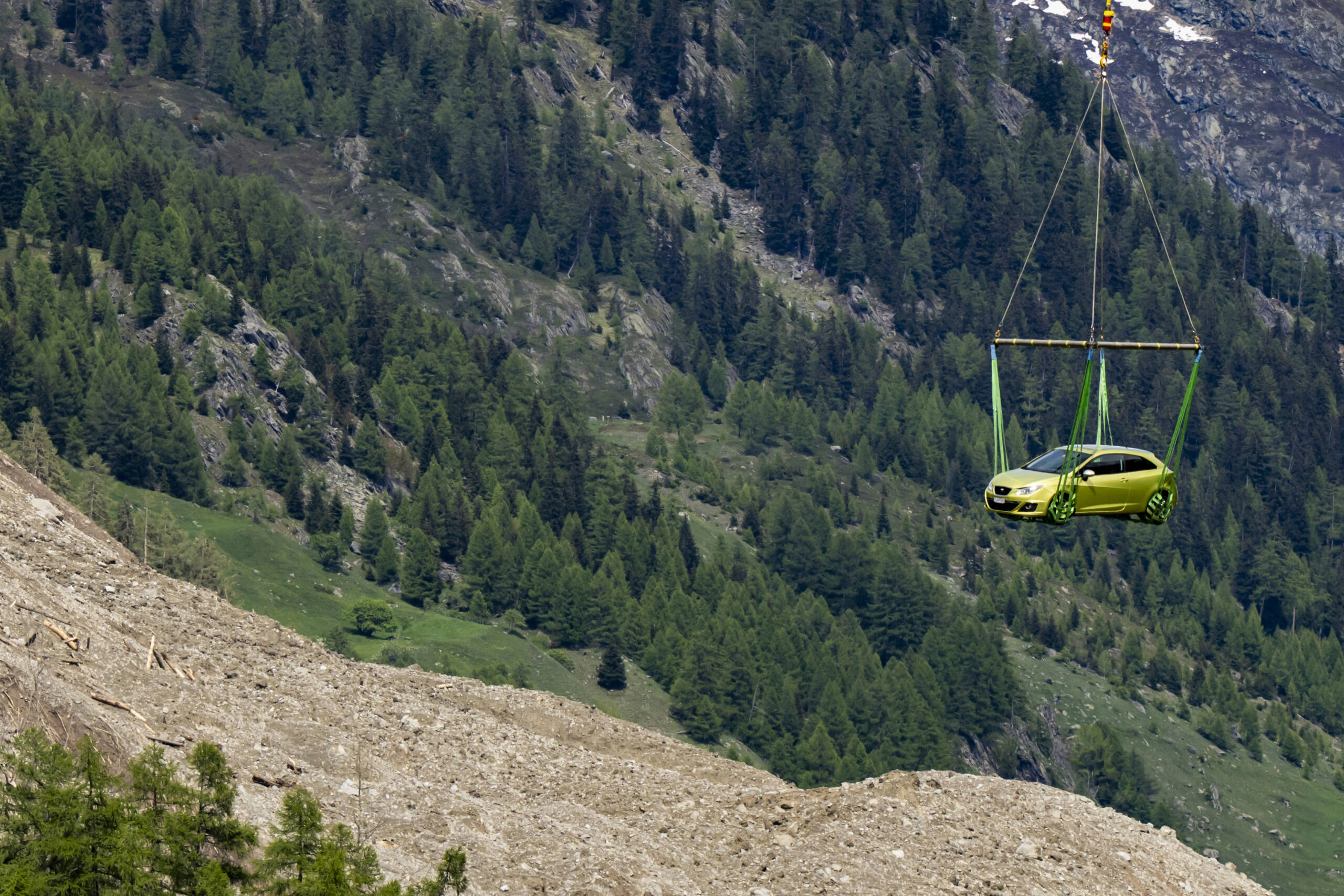 Un hélicoptère évacue une voiture du village de Blatten, en Suisse, le jeudi 29 mai 2025, au lendemain d'une énorme avalanche de débris, provoquée par l'effondrement du glacier Birch, qui a balayé le fond de la vallée et détruit une grande partie du village. © Jean-Christophe Bott/Keystone via AP