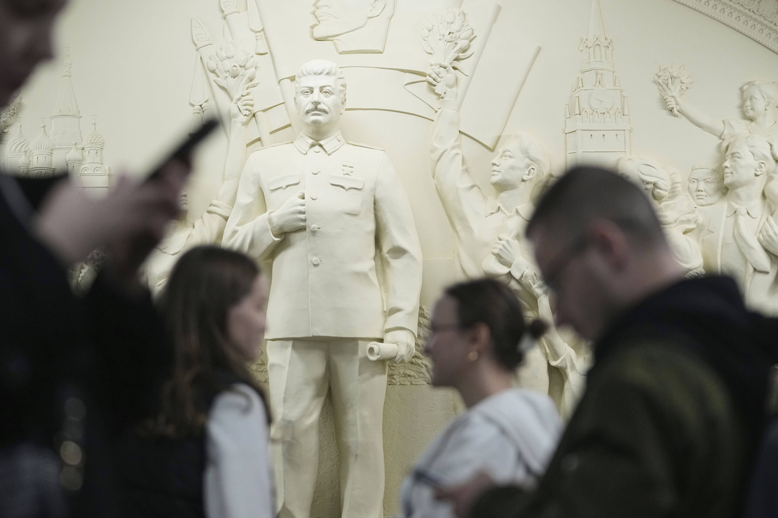 Des passants devant un bas-relief restauré dans la station de métro Taganskaya à Moscou, en Russie, le jeudi 15 mai 2025, à l'occasion du 90e anniversaire de l'inauguration du métro de Moscou. © AP Photo/Pavel Bednyakov