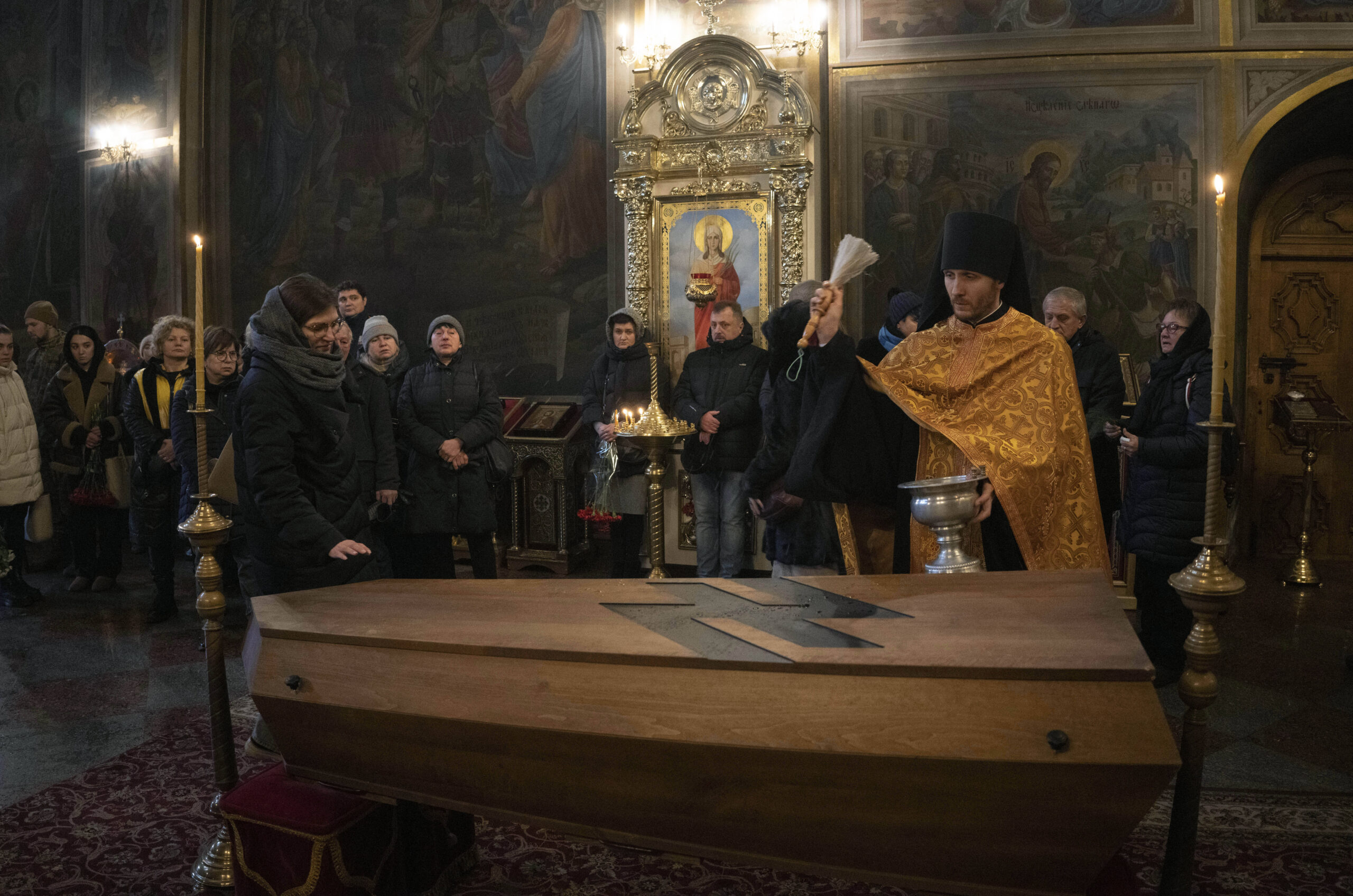Un prêtre prie devant le cercueil d'Oleksandr Grianyk du régiment Azov, tué le 8 mai en défendant Mariupol contre les Russes, lors de la cérémonie funéraire dans la cathédrale Saint-Michel, Kiev, samedi 14 janvier 2023. © AP Photo/Efrem Lukatsky