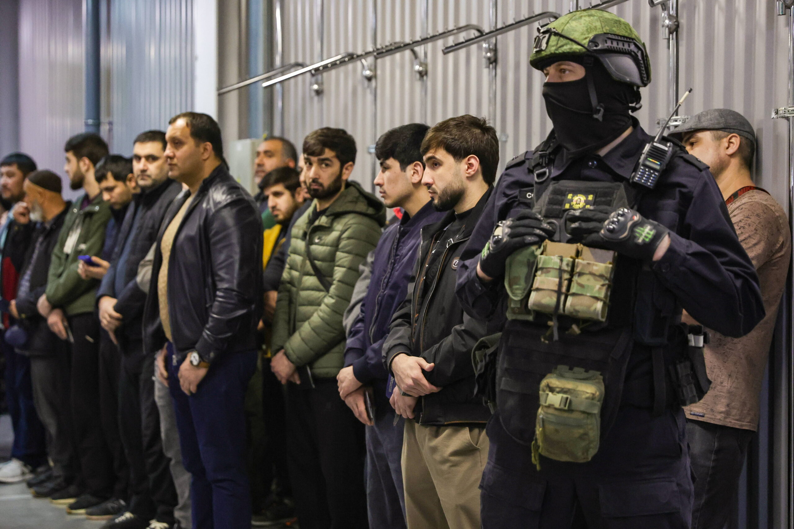 Des employés présentent leurs documents à un agent du Comité d'enquête lors d'une descente de police visant à faire respecter l'enregistrement militaire des migrants au centre de vente en gros et au détail Nordmoll, situé au nord de Novosibirsk. © Kirill Kukhmar/TASS/Sipa USA