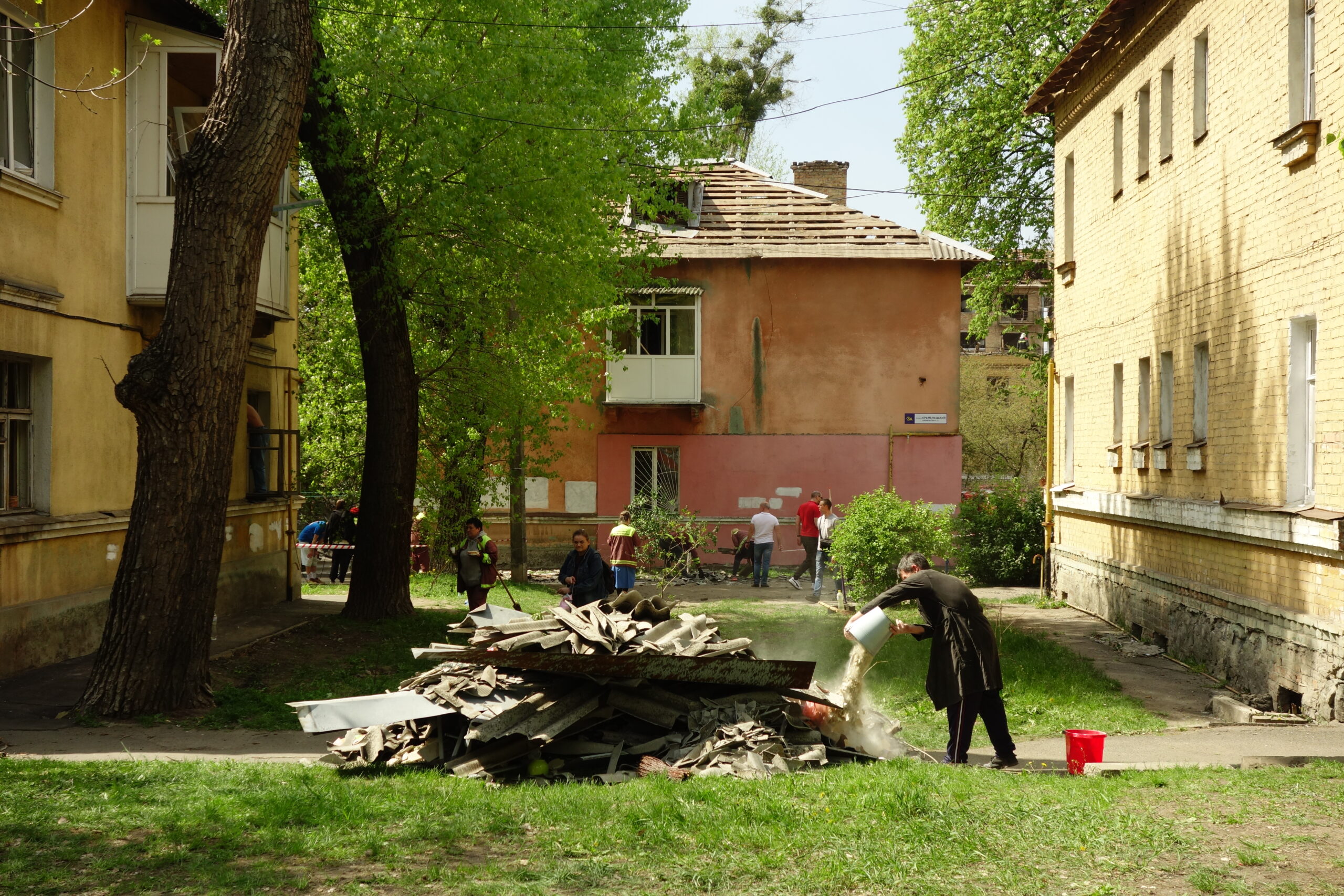Un homme ramasse des débris après une frappe de missile ballistique sur un immeuble de Kyiv, 24 avril 2025.
