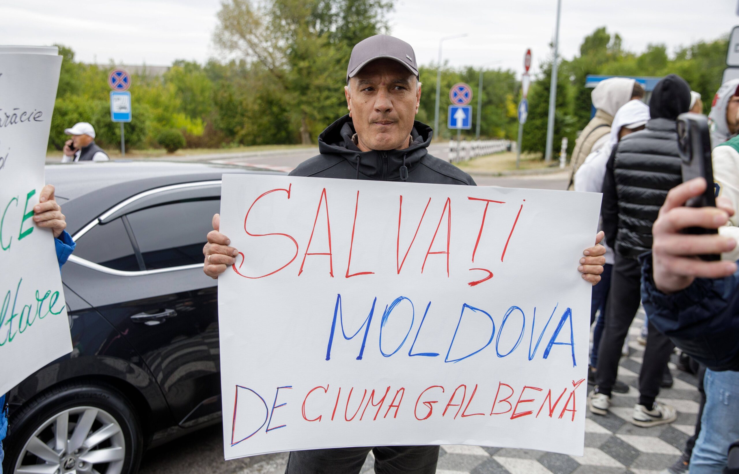 Un manifestant brandit une banderole sur laquelle on peut lire «Sauvez la Moldavie du fléau jaune», la couleur du PAS, le parti de Maia Sandu.