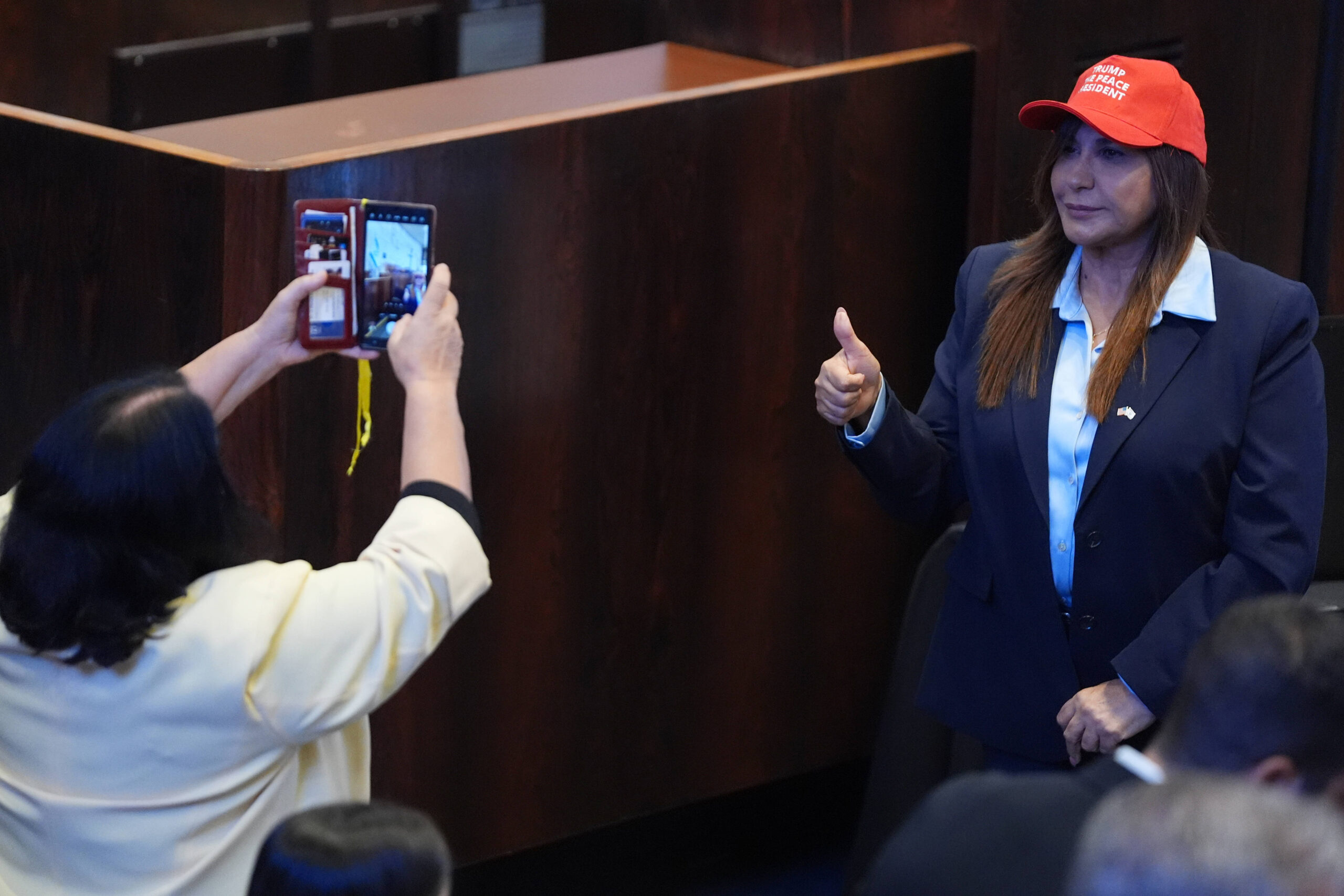 Une personne pose pour une photo avant que le président Donald Trump ne s'adresse à la Knesset, le parlement israélien, le lundi 13 octobre 2025, à Jérusalem. © AP Photo/Evan Vucci