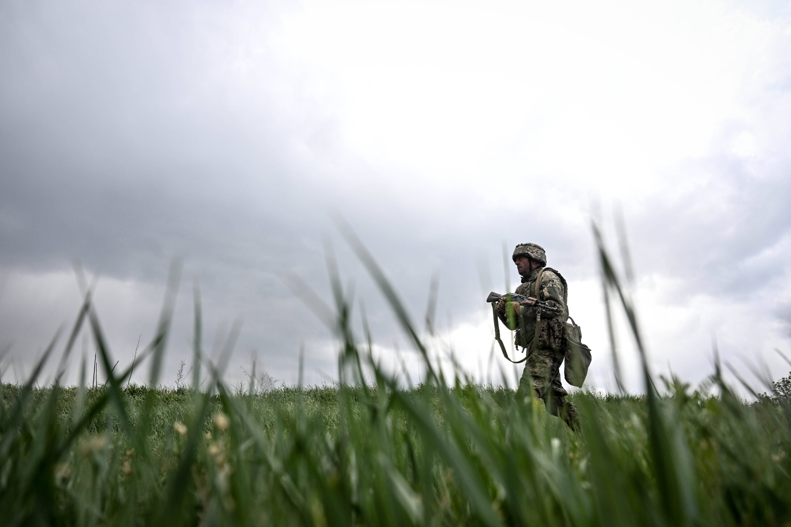 Un soldat armé de la 141e brigade mécanisée indépendante des forces terrestres ukrainiennes traverse un champ alors qu'il participe à un exercice de coordination de combat, en Ukraine, le 14 mai 2025. © Dmytro Smolienko/Ukrinform/SIPA