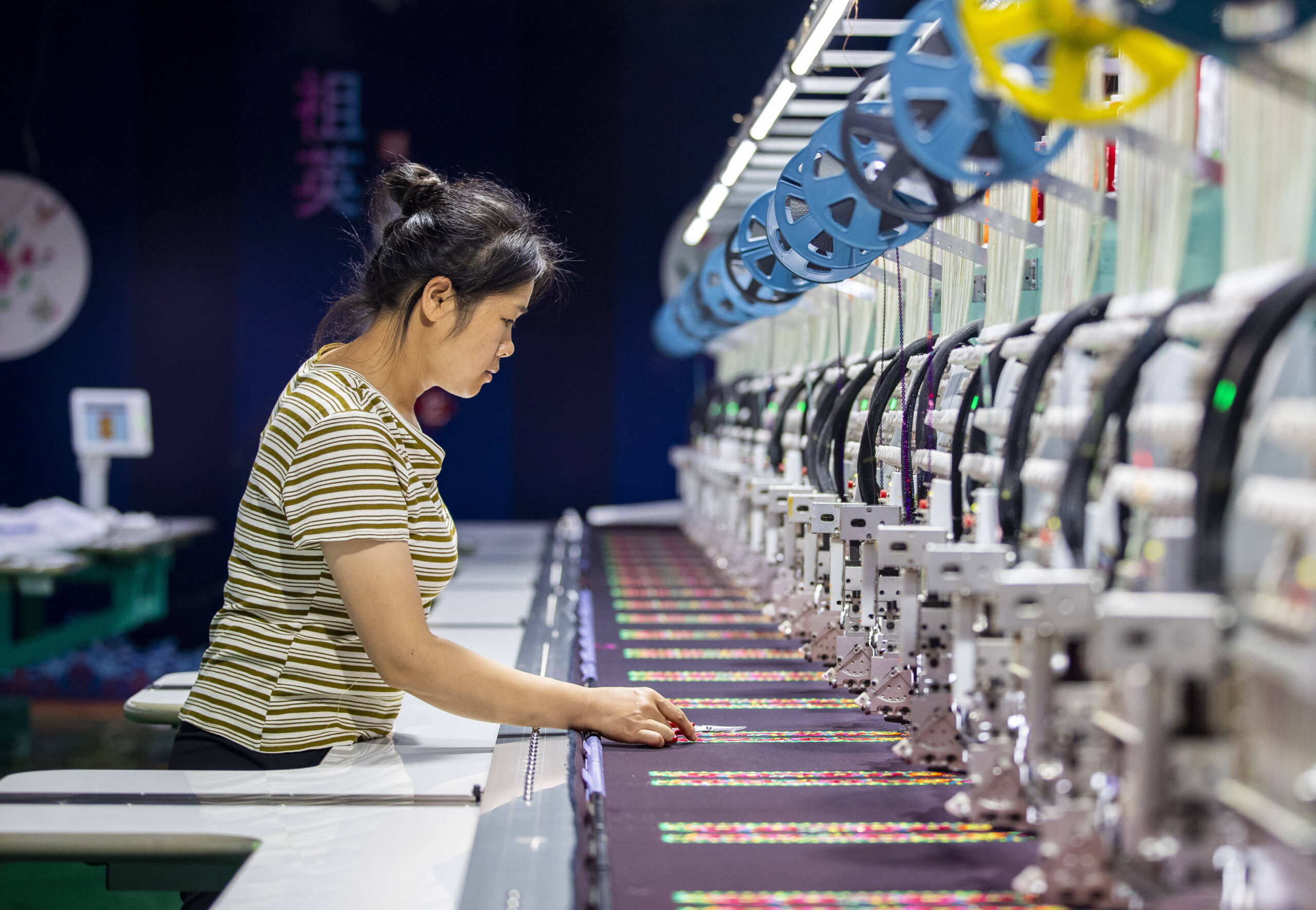 Une ouvrière utilise une machine CNC pour fabriquer des produits brodés dans l'atelier de production d'une entreprise de broderie ethnique, dans le comté de Congjiang en Chine, le 8 octobre 2025. © CFOTO/Sipa USA