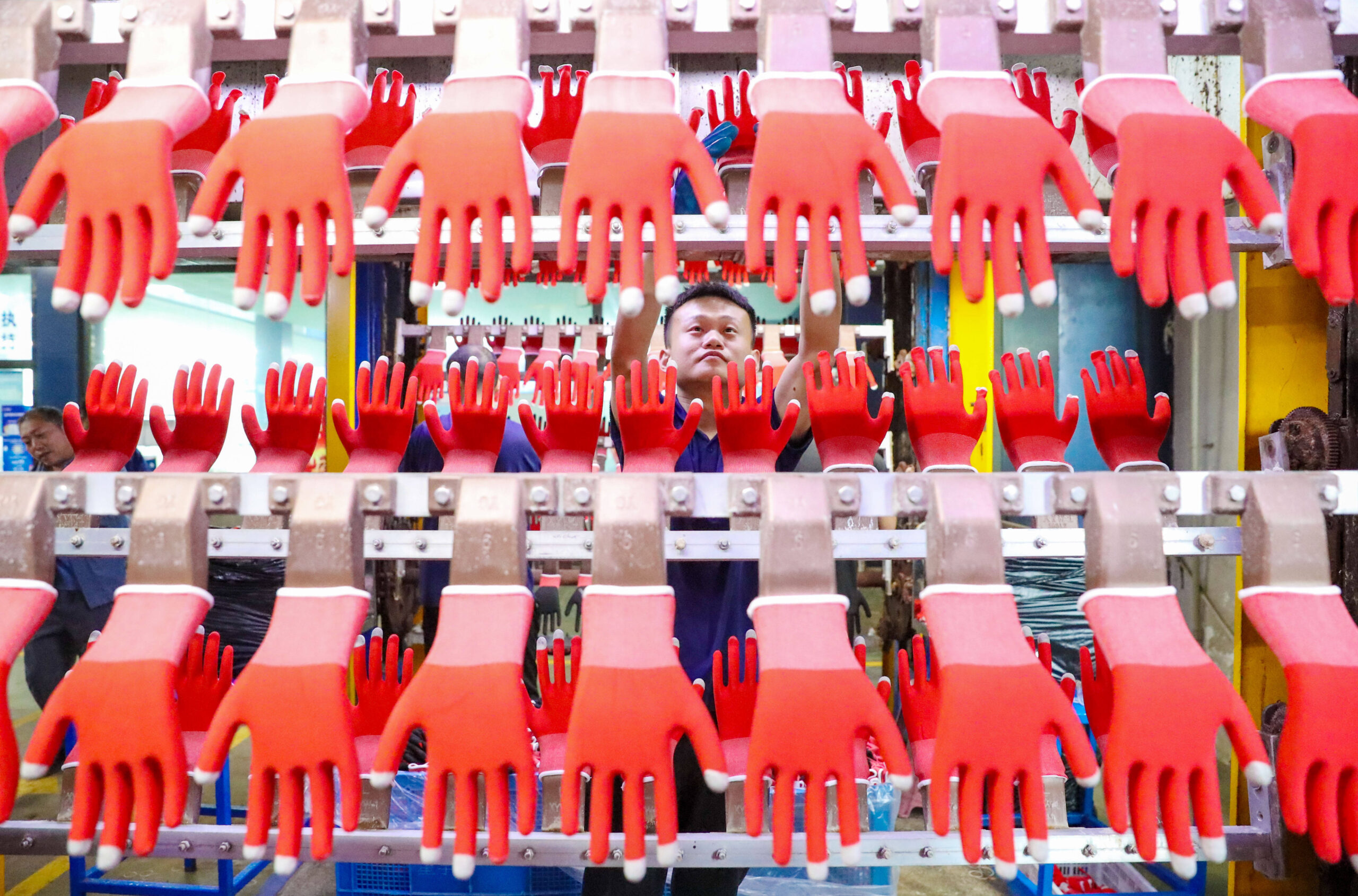 Un ouvrier fabrique des gants de protection dans un atelier de production à Gaomi, dans la province du Shandong, en Chine, le 12 octobre 2025. © CFOTO/Sipa USA. 