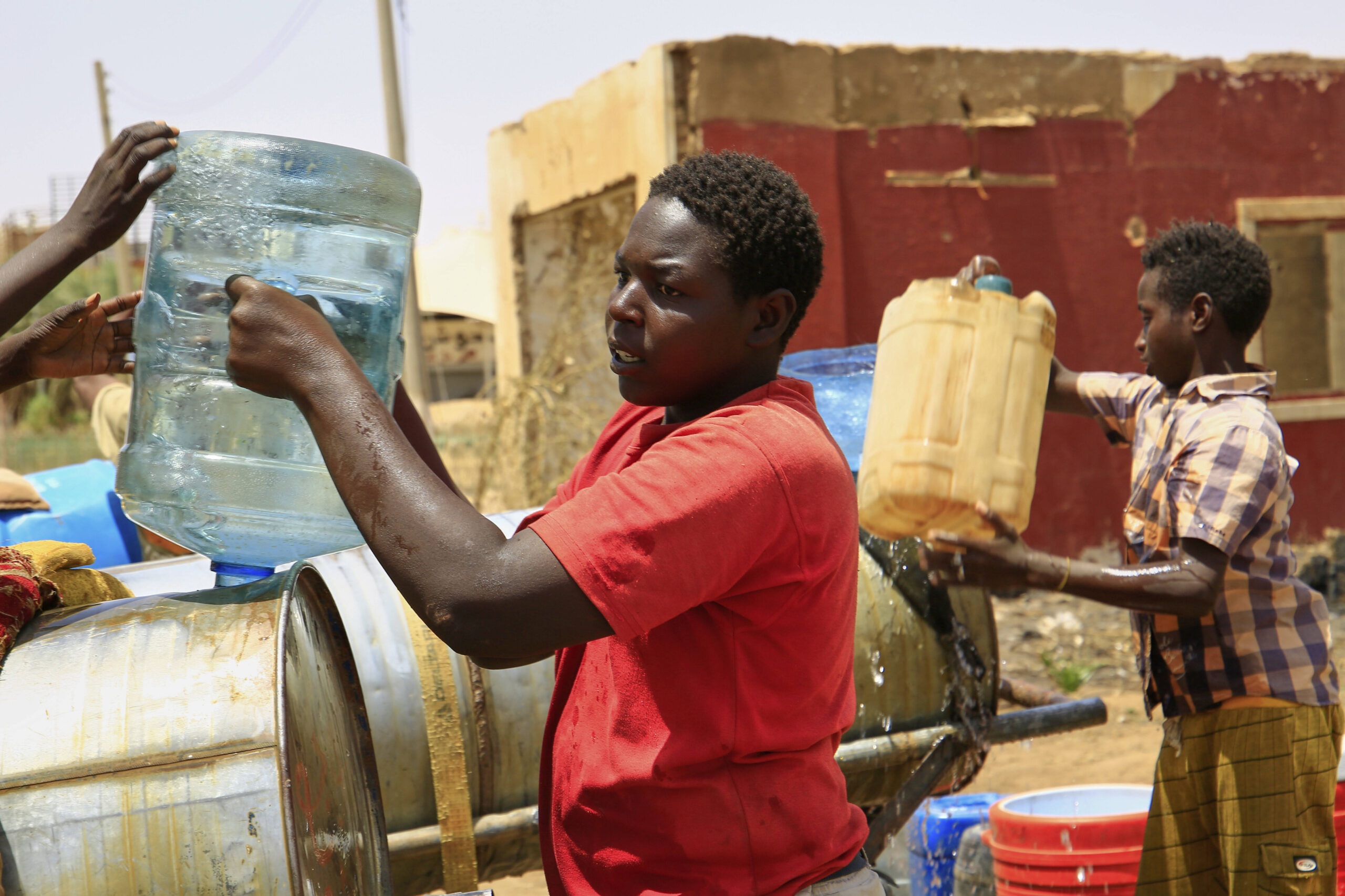 Des habitants remplissent des bidons après une coupure d'eau à Khartoum, au Soudan, le dimanche 25 mai 2025. © AP Photo/Sipa