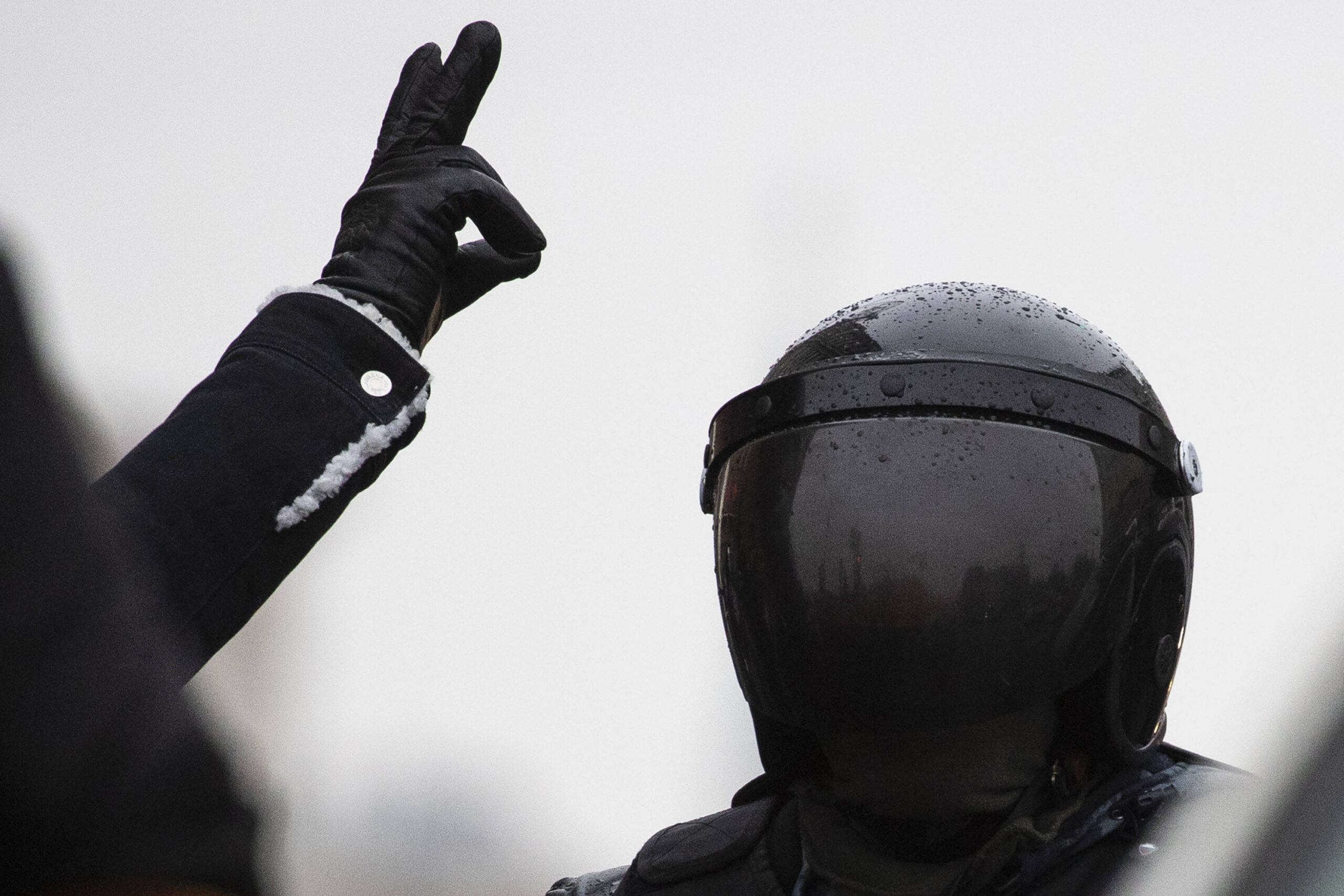 Un homme fait un geste alors qu'un policier, à droite, monte la garde lors d'une manifestation contre l'emprisonnement du leader de l'opposition Alexei Navalny à Moscou, en Russie, le samedi 23 janvier 2021. (© AP Photo/Pavel Golovkin)
