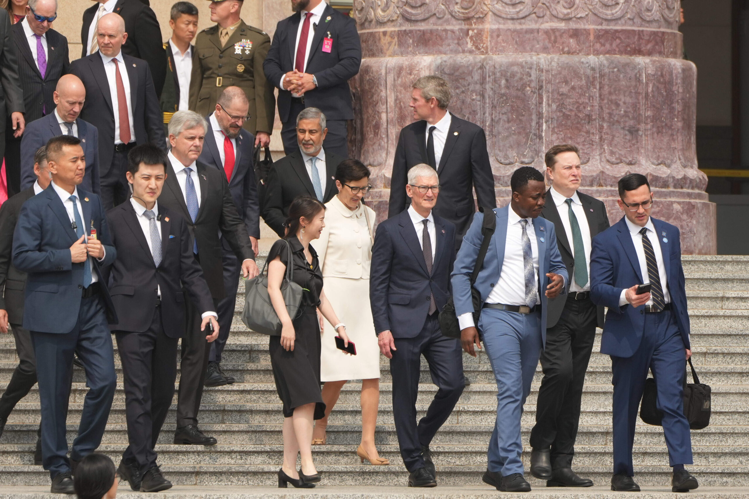 Des membres de la délégation américaine, dont le PDG d'Apple Tim Cook arrivent avant que le président Donald Trump ne soit accueilli par le président chinois Xi Jinping lors d'une cérémonie de bienvenue au Grand Hall du Peuple, le jeudi 14 mai 2026, à Pékin. © AP Photo/Mark Schiefelbein