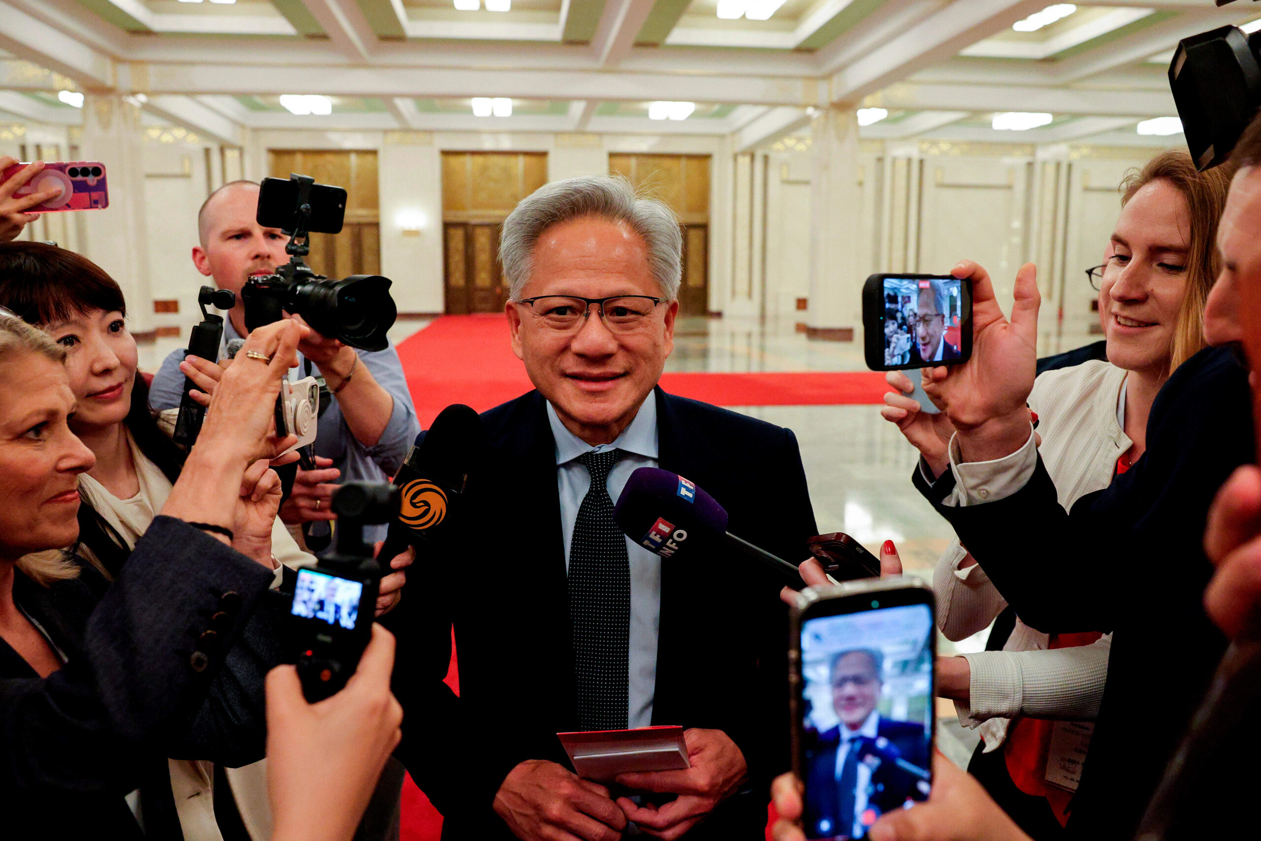 Jensen Huang, PDG de Nvidia, s'adresse aux médias alors qu'il assiste à une réunion entre le Premier ministre chinois Li Qiang et des représentants du monde des affaires américain, au Grand Hall du Peuple à Pékin, le jeudi 14 mai 2026. © Go Nakamura